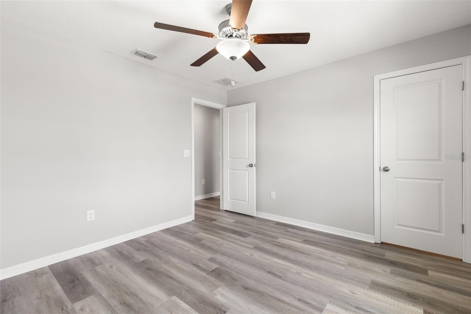Bedroom 3 includes a built-in closet, newly replaced laminate flooring, fresh neutral paint and a ceiling fan, with plenty of wall space for a flexible furniture layout. - 5061 WHITE CHICORY DR, APOLLO BEACH