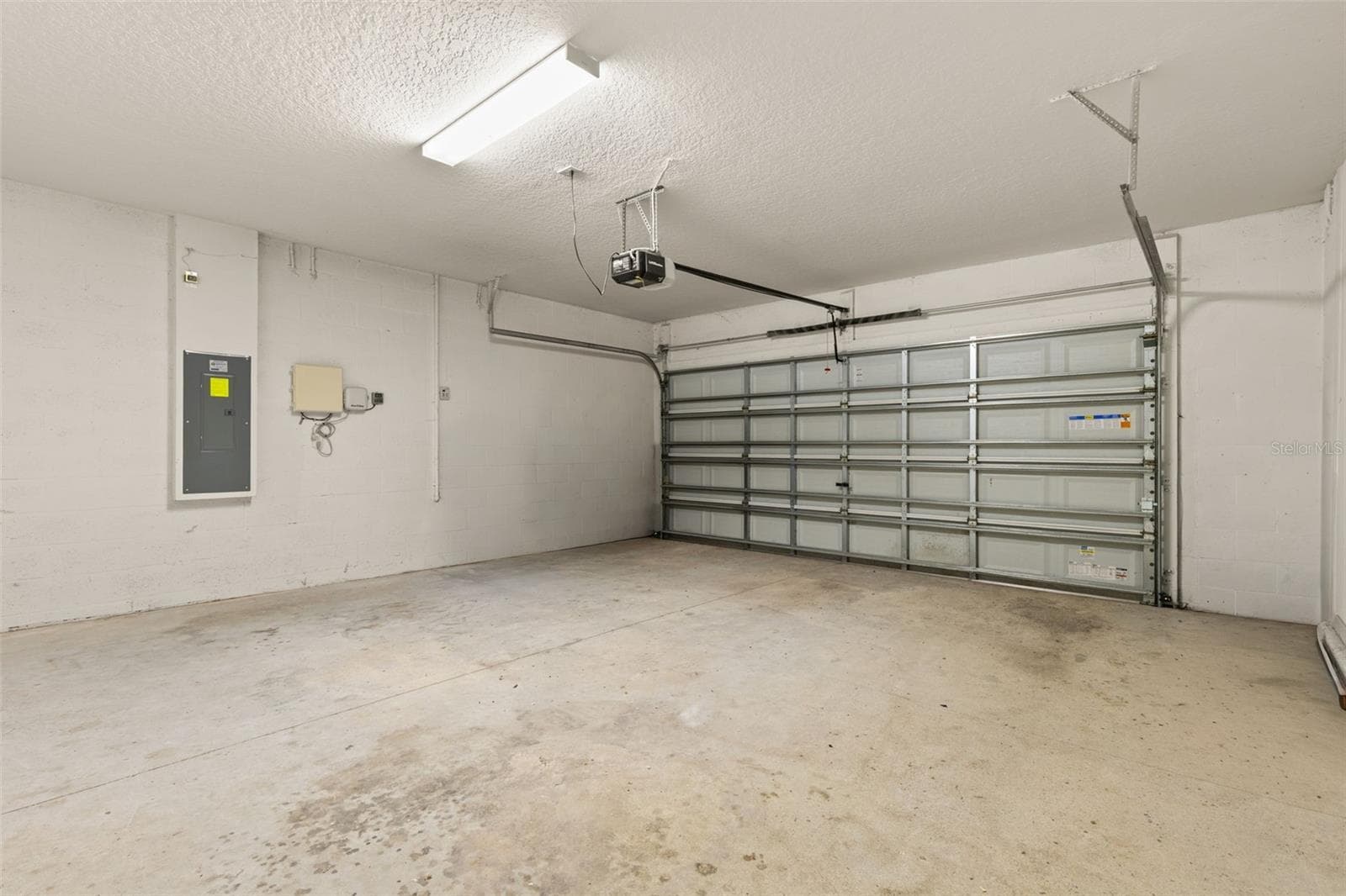 The two-car garage includes an automatic opener, overhead lighting and a clean, open footprint with room for parking, storage and everyday gear. - 5061 WHITE CHICORY DR, APOLLO BEACH