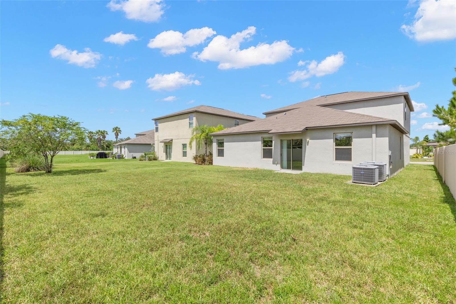 The oversized backyard offers a broad stretch of open lawn with room for a future pool, patio, play area or outdoor entertaining space, while privacy fencing adds separation along the property line. - 5061 WHITE CHICORY DR, APOLLO BEACH