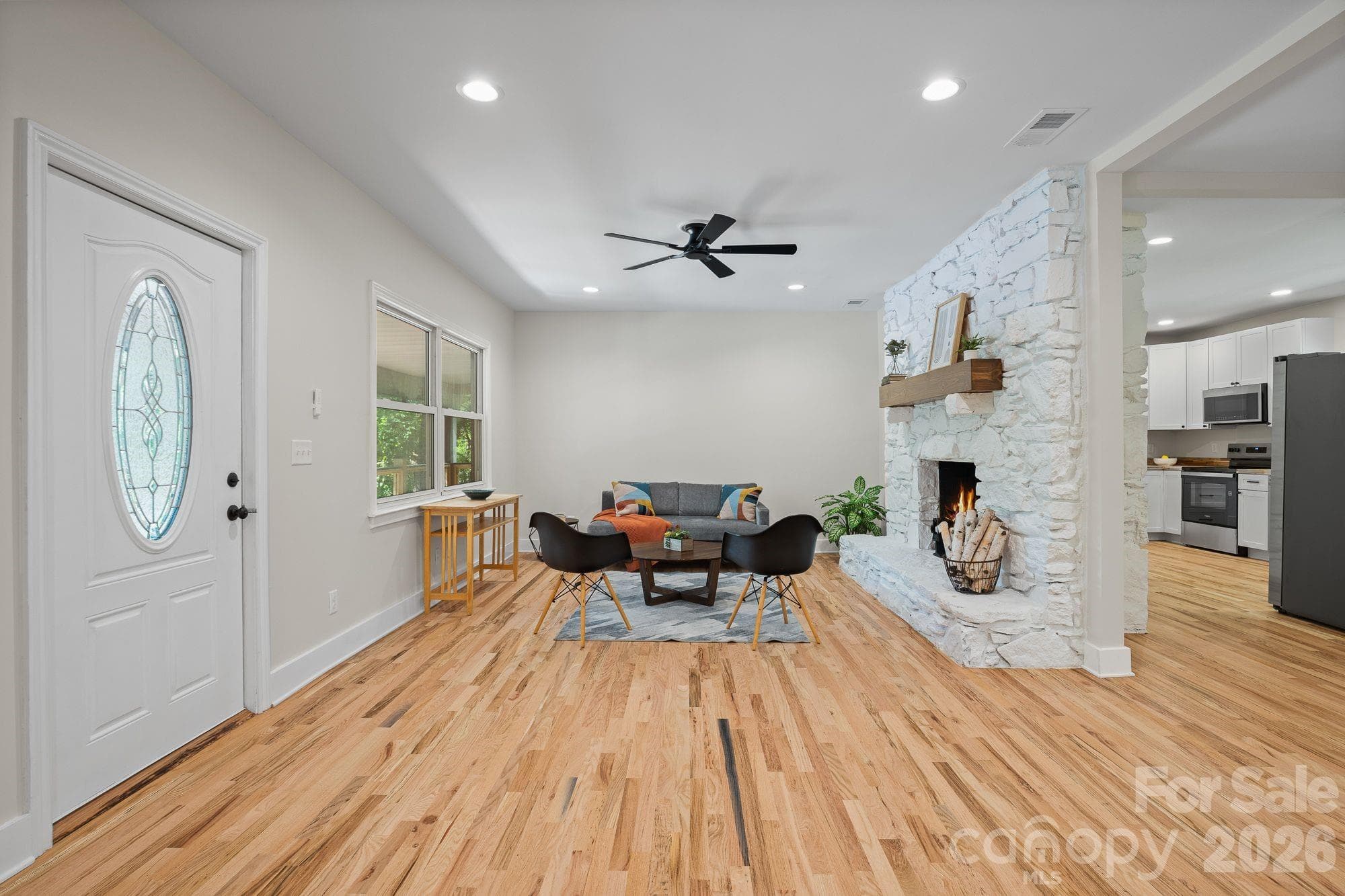 Spacious open living area anchored by a stone wood-burning fireplace. - 156 State Street, Asheville