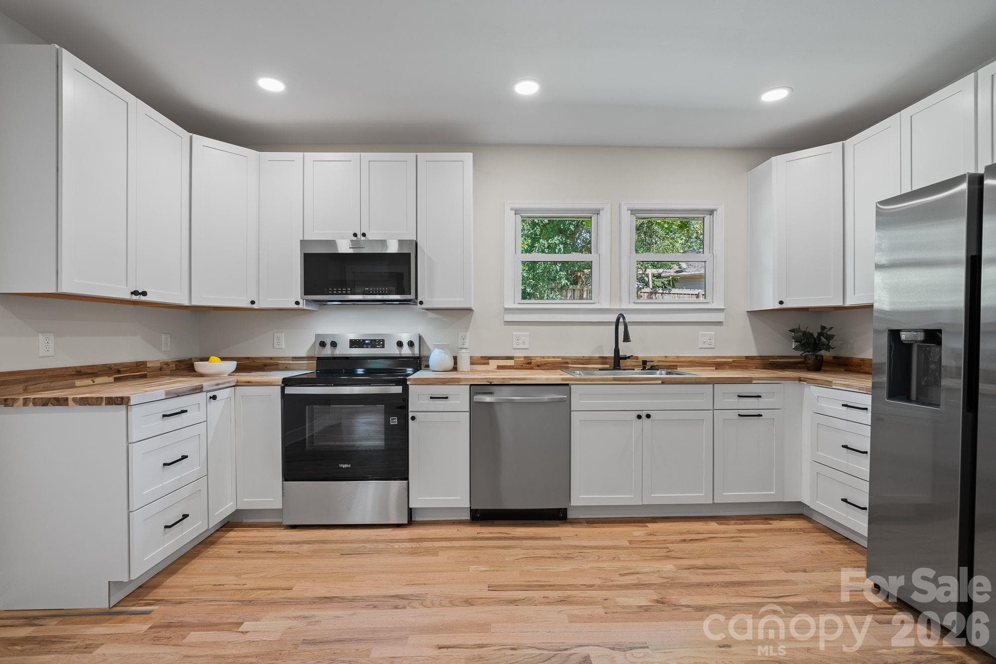 Kitchen: Renovated kitchen featuring butcher block countertops and new stainless steel appliances. - 156 State Street, Asheville