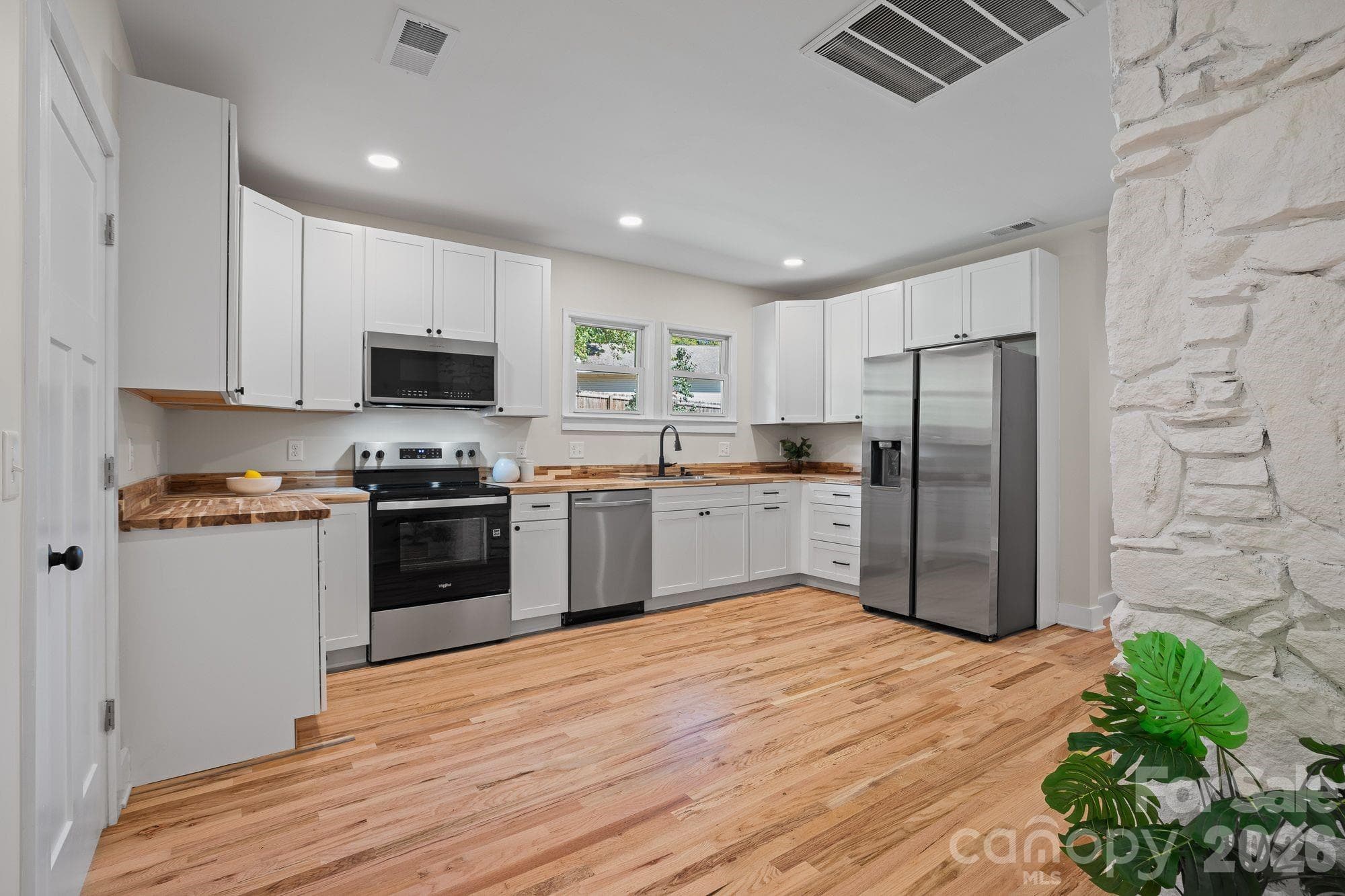 Kitchen: Renovated kitchen featuring butcher block countertops and new stainless steel appliances. - 156 State Street, Asheville