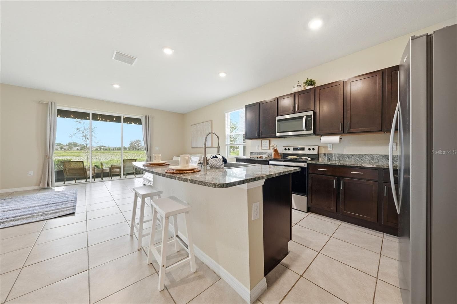 Kitchen has an abundant amount of cabinets, stainless steel appliances, deep single-basin kitchen sink and a waterfall sink! - 5238 DRAGONFLY DR, WILDWOOD
