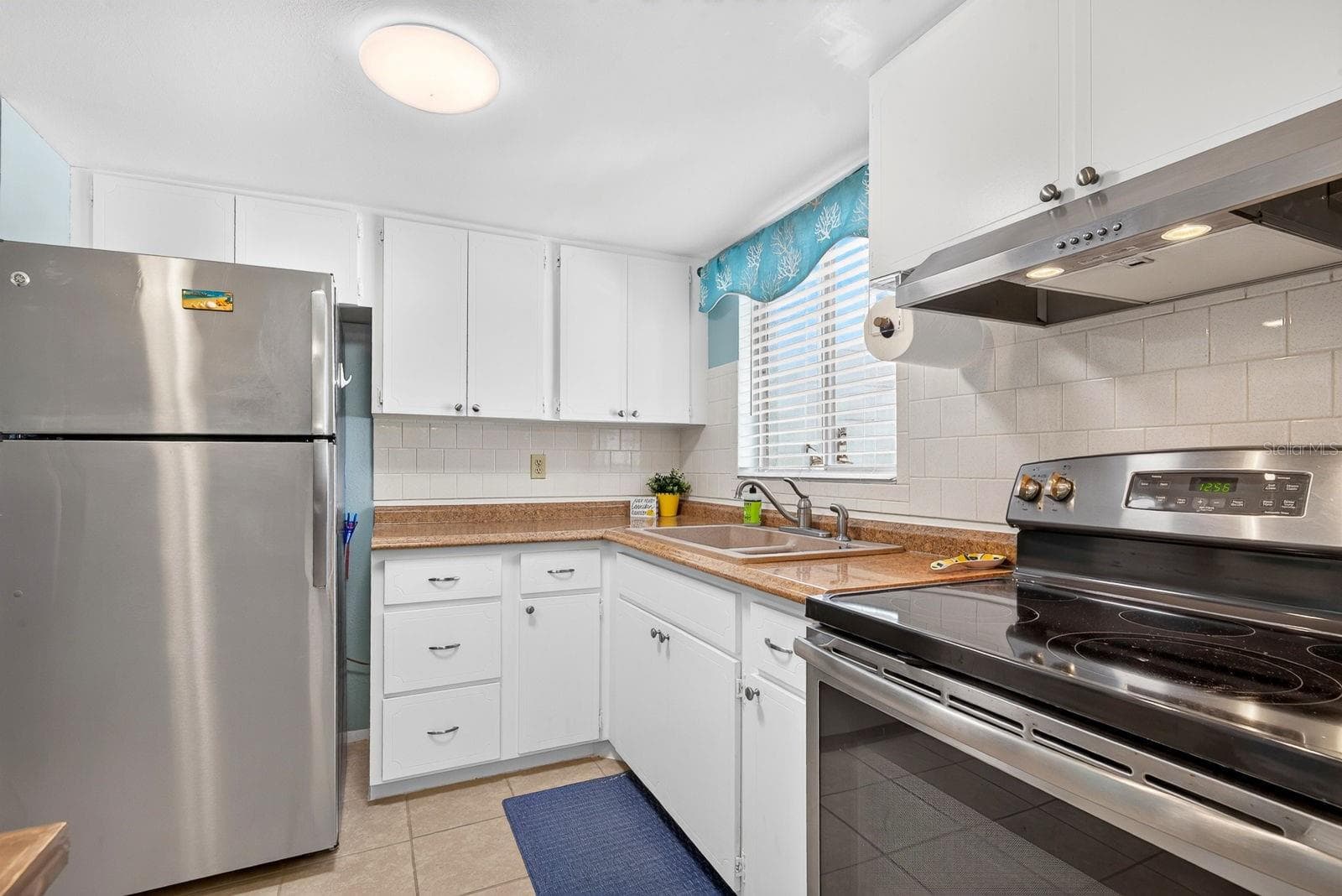 Kitchen with updated appliances and white tile back splash - 5853 PALM LN #B7, BRADENTON