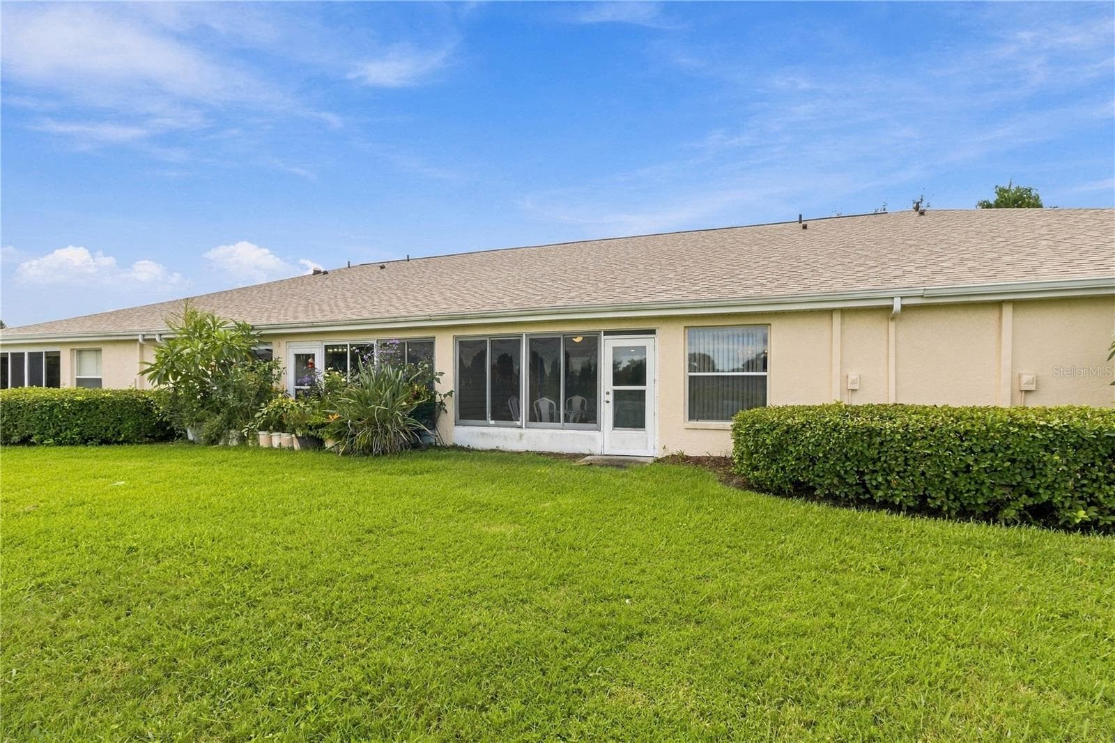 Rear view showcasing the home’s spacious outdoor living area - 1002 NICENE CT #47, SUN CITY CENTER