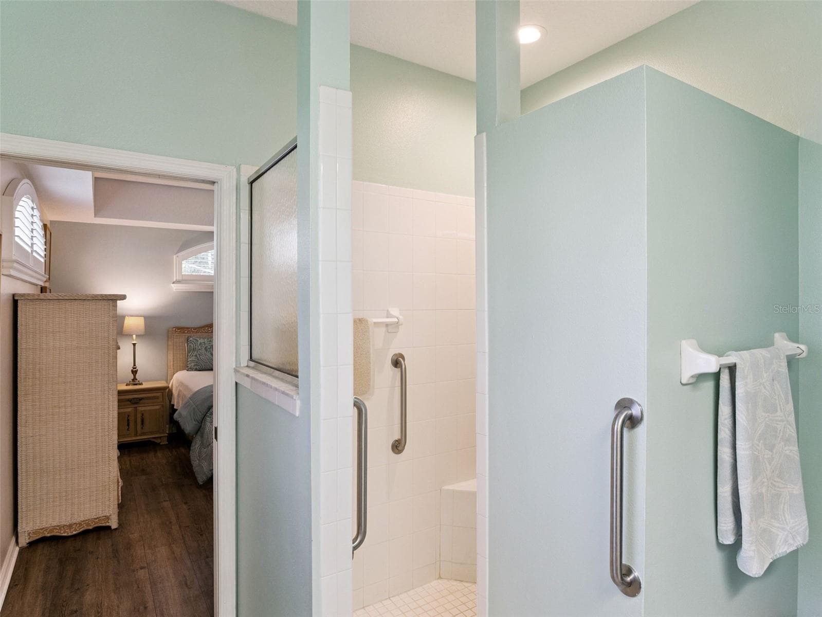 Primary en suite ~ the walk-in shower has a built-in bench and grab bars for safety. - 5401 ESSEX CT, LEESBURG