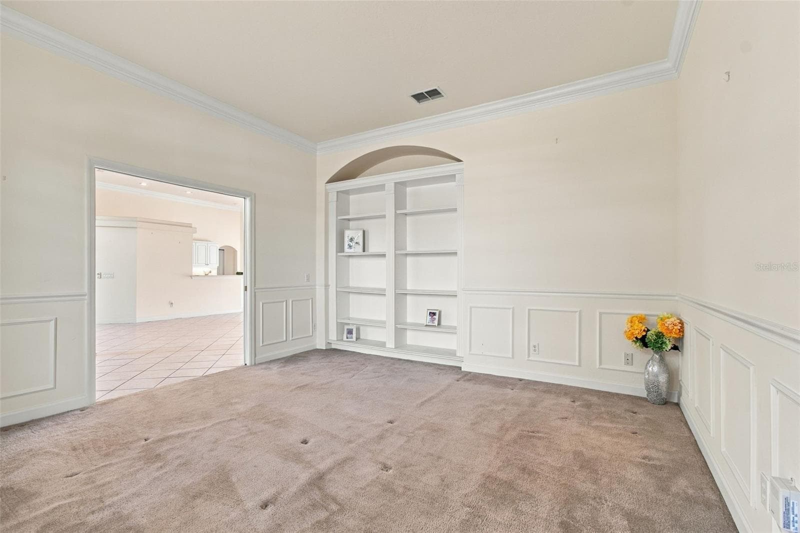 Your flex room with double pocket doors, a custom build in shelf, custom wall paneling and window bench seat. - 1301 FOX CHAPEL DR, LUTZ