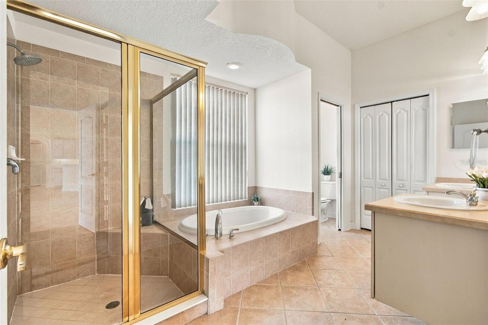 Your walk in shower features a shower rain head and a built in shower bench. - 1301 FOX CHAPEL DR, LUTZ