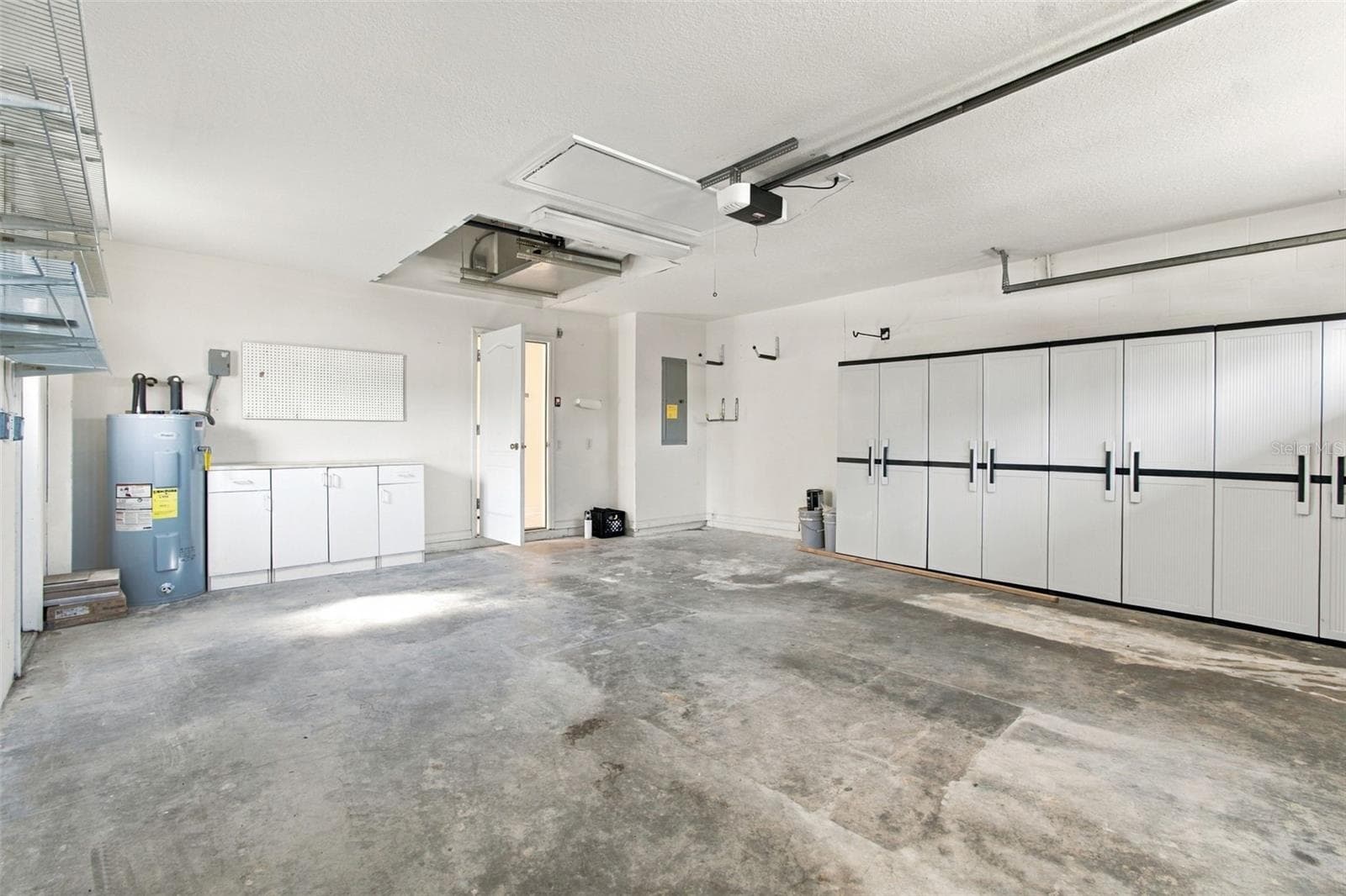 Your garage with wall storage units and a new garage system. - 1301 FOX CHAPEL DR, LUTZ