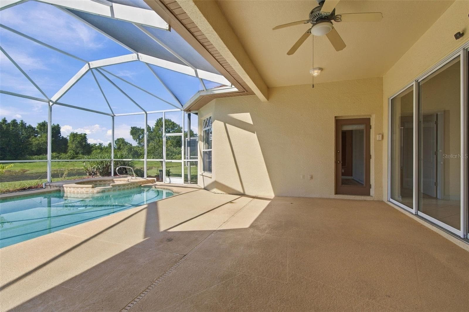 Your screened lanai features three access entries from the home.  The primary bedroom and secondary  bathr offers access doors.  The family room offers a double sliding glass door. - 1301 FOX CHAPEL DR, LUTZ