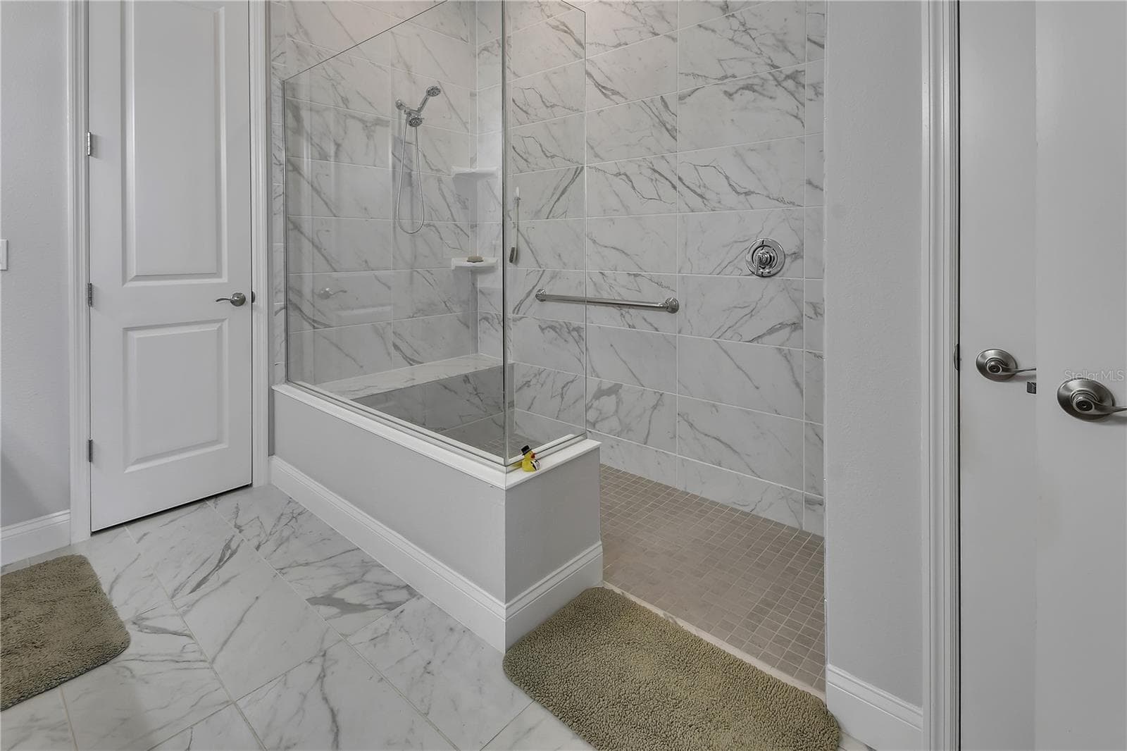 Walk-in shower has bench and grab bar. Privacy Lavatory. - 1011 MEGANO BLVD, DELAND