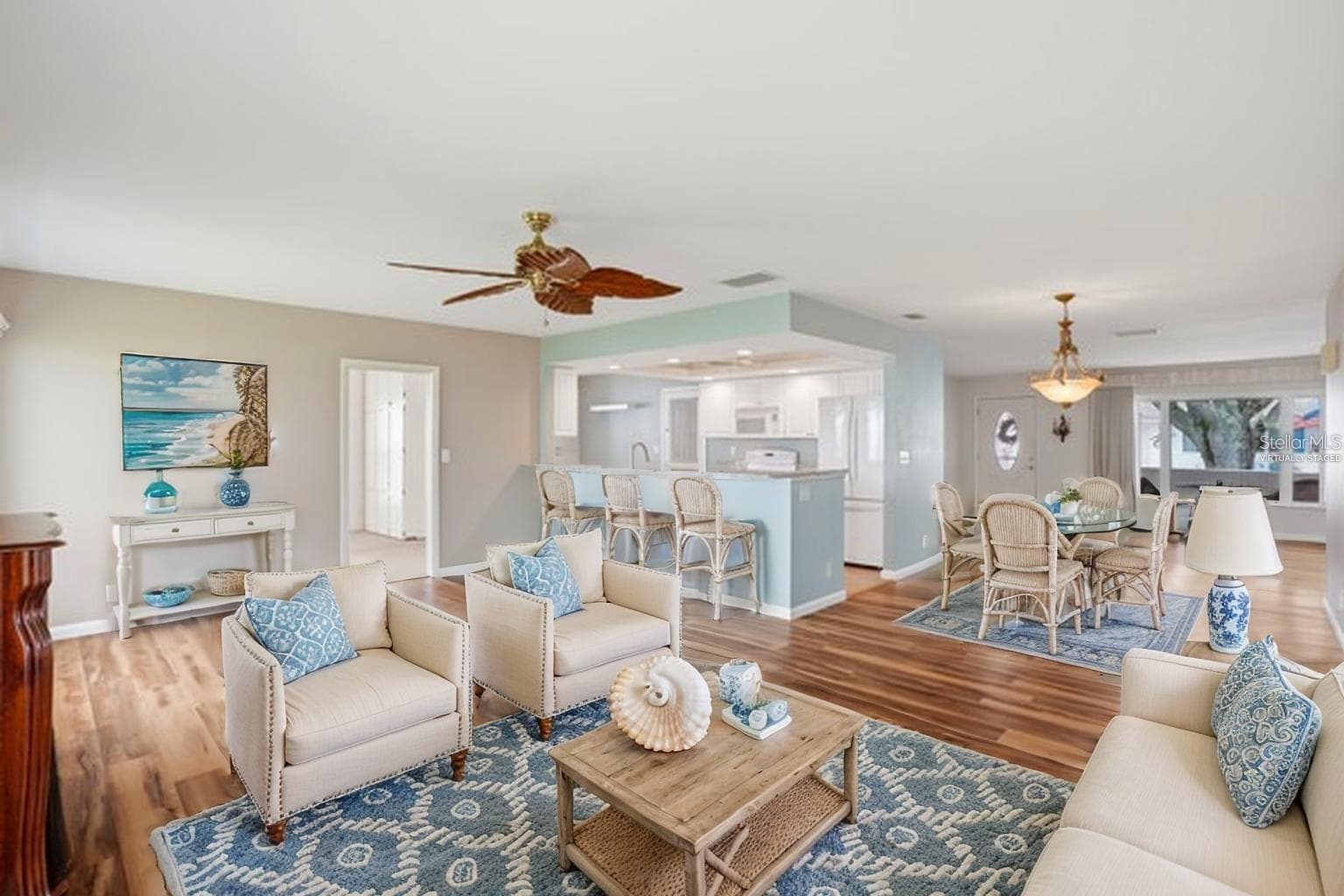 Virtually staged family room with bar stools at the kitchen counter. - 3939 90TH TER N, PINELLAS PARK