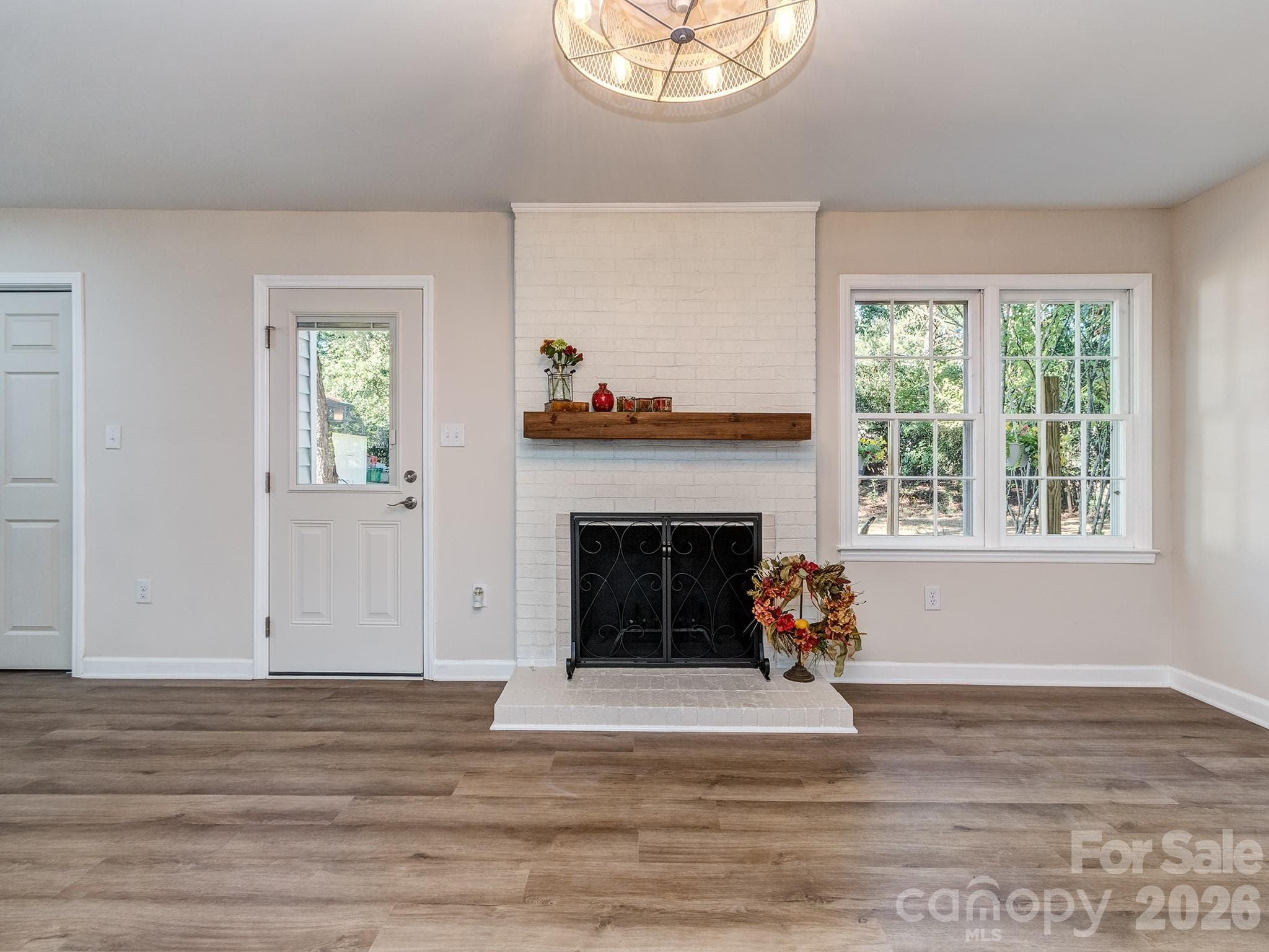 The beautiful wood mantle is just waiting for your decor with a 2 door fireplace screen for easy access to tend to a fire. The fandelier has a remote and provides many light and fan speed options for a cozy space to relax. Back entry door has built in miniblinds between the double panes for open, part or full privacy. - 2041 Glouchester Circle, Charlotte