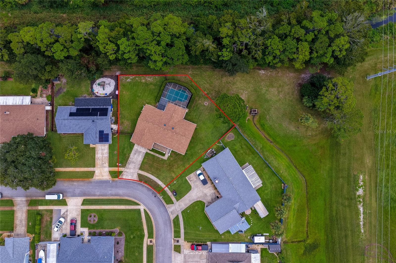 Overhead aerial shot outlining the expansive property boundary, screened pool enclosure, and surrounding green spaces. - 4669 SECRET RIVER TRL, PORT ORANGE