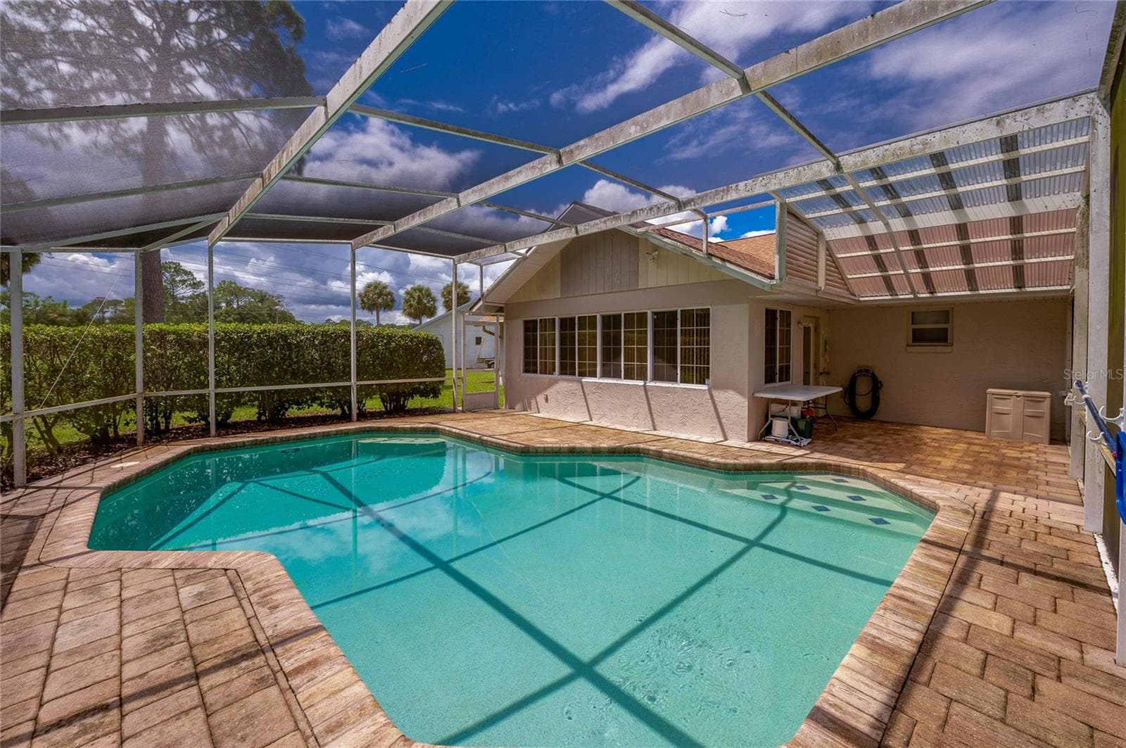 Spacious screened lanai showcasing an in-ground swimming pool, brick pavers, and direct access to the home. - 4669 SECRET RIVER TRL, PORT ORANGE