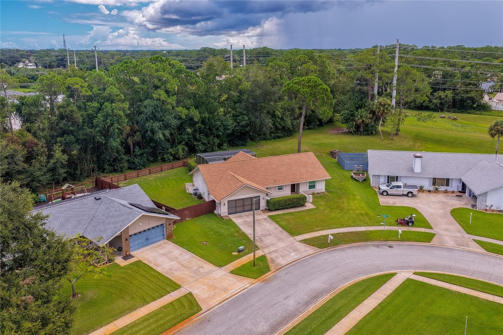 Elevated neighborhood view displaying the property's location along a quiet residential street bordered by mature trees. - 4669 SECRET RIVER TRL, PORT ORANGE