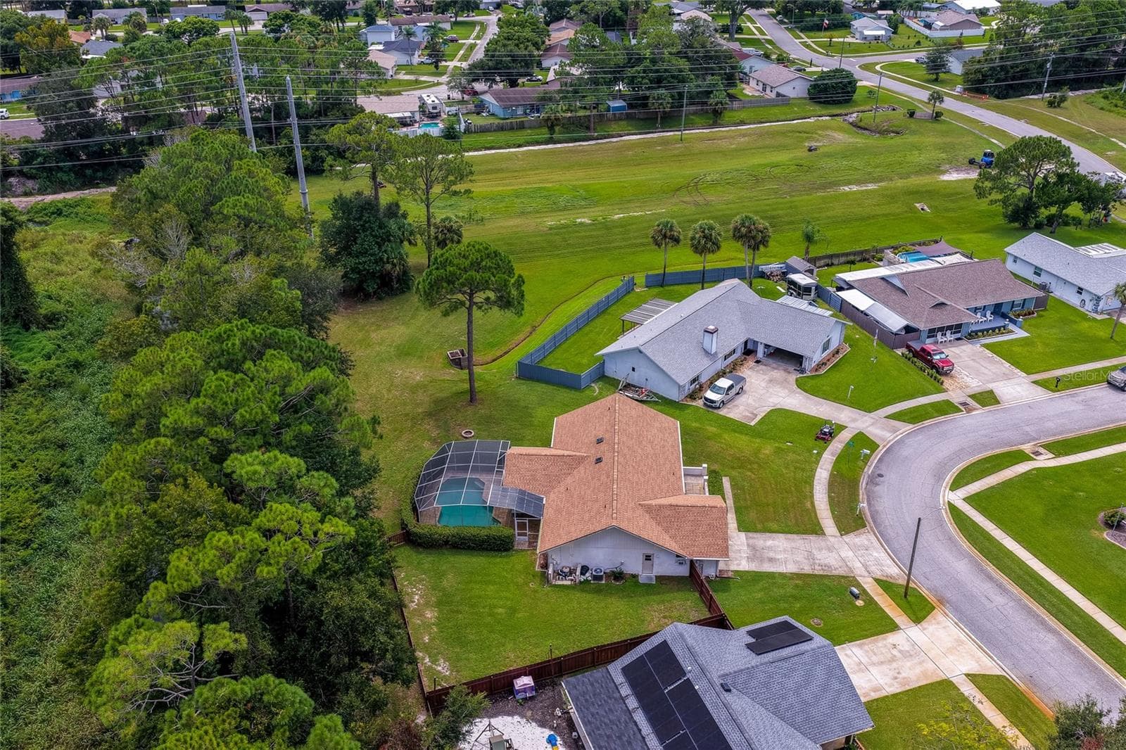 Angled aerial photo capturing the home placement, screened lanai, and generous lot size. - 4669 SECRET RIVER TRL, PORT ORANGE