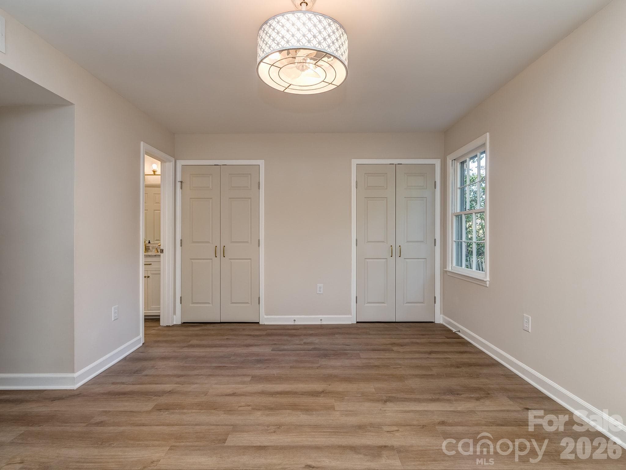 Primary Bedroom on the main floor has nice sized dual closets. Fandalier can be used from a remote that lets you set the dimmable lighting and fan speeds. Front and side windows provide for wonderful natural light. - 2041 Glouchester Circle, Charlotte