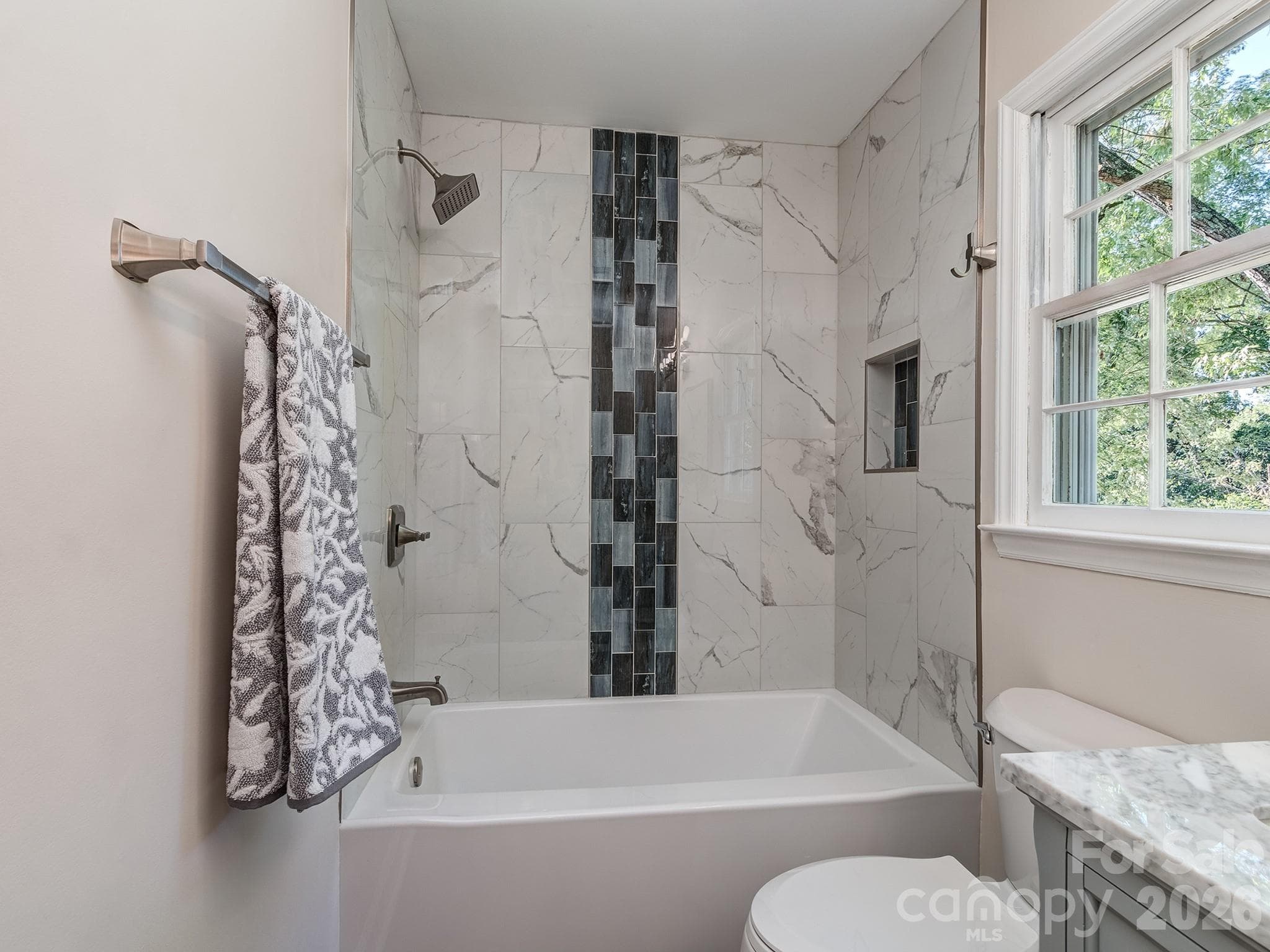 Bathroom has custom tile in soaking bathtub, brushed nickel fixtures and hardware and a nice size window for natural lighting. - 2041 Glouchester Circle, Charlotte