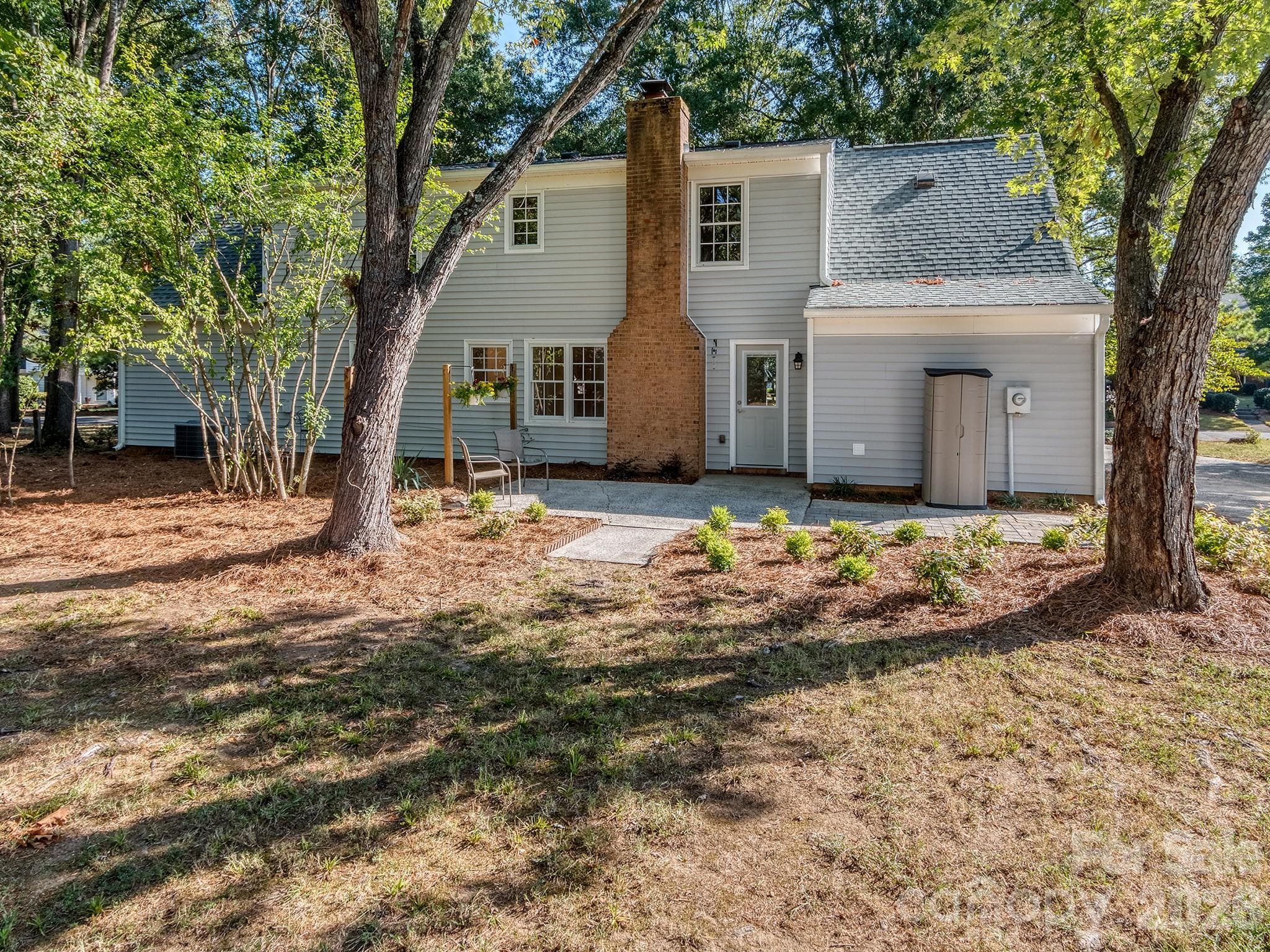 Back of the house boasts a large patio for outside seating and dining. Nicely landscaped and mature trees provide shade at mid-day and evening. - 2041 Glouchester Circle, Charlotte