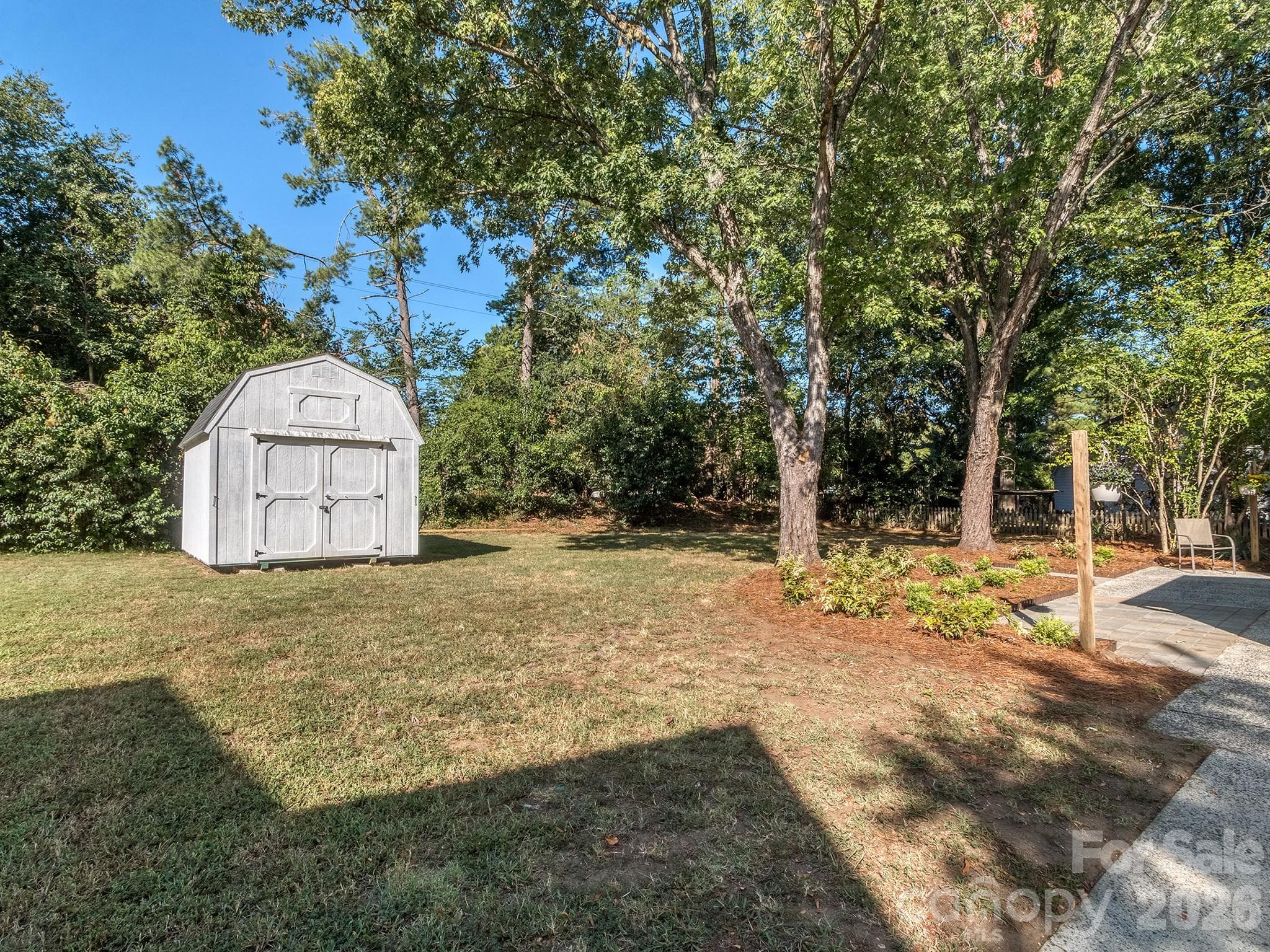 Nice size flat backyard great for entertaining and outdoor activities. This shed is large and can be a work space or storage for all your lawn equipment, outdoor recreational equipment, extra storage, etc. Treed buffer at rear of property provides extra privacy. - 2041 Glouchester Circle, Charlotte