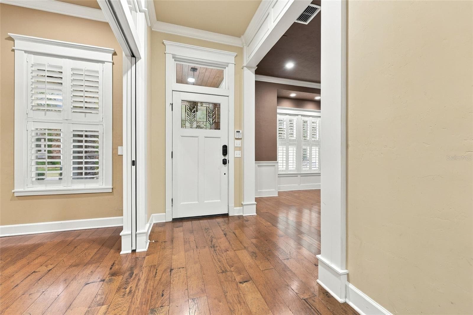 Front foyer: Wood floors in foyer, dining room, study, kitchen, living room & primary bedroom - 734 SW 134TH WAY, NEWBERRY