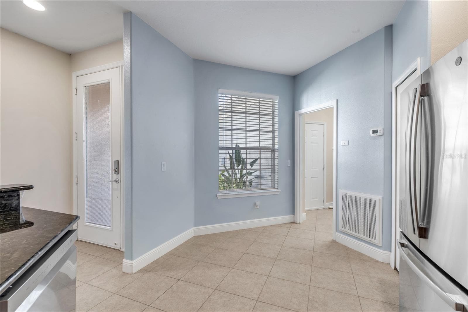front door entry way leading into the kitchen, further into the laundry and garage - 128 BAUER CIR, DAYTONA BEACH