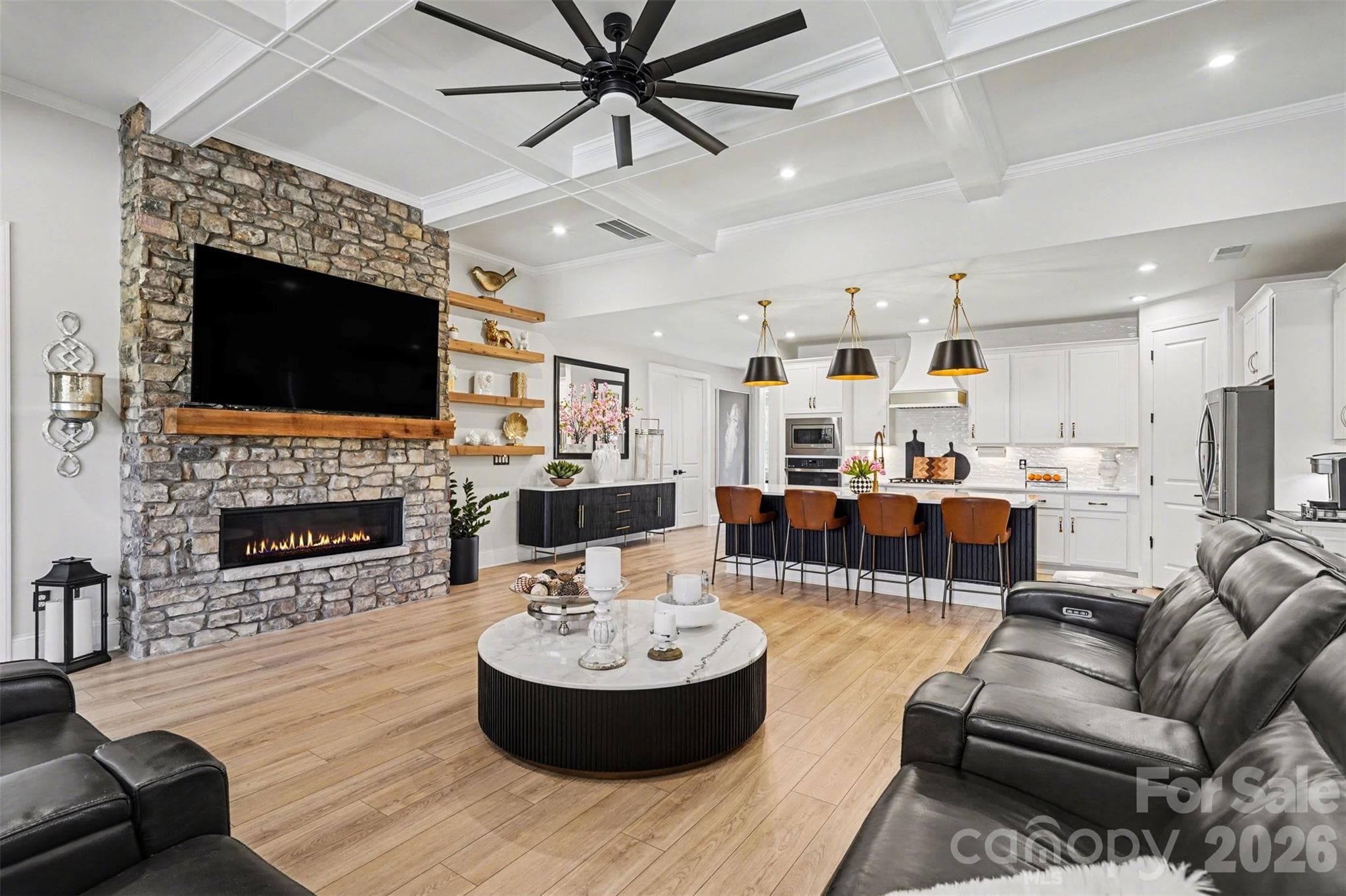 Open living, kitchen, and dining under a coffered ceiling. - 8027 Longwaters Court, York