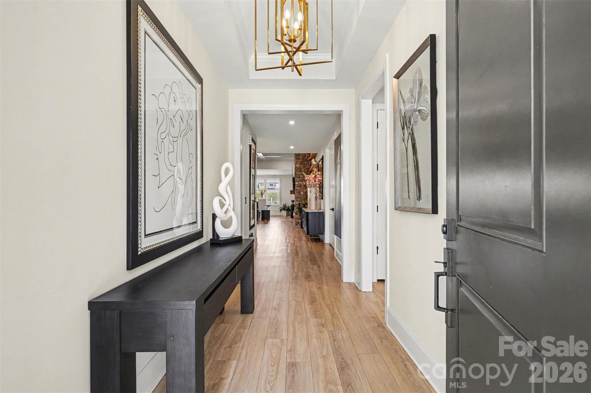 A gold chandelier and a long open hall that pulls you right into the heart of the home. - 8027 Longwaters Court, York