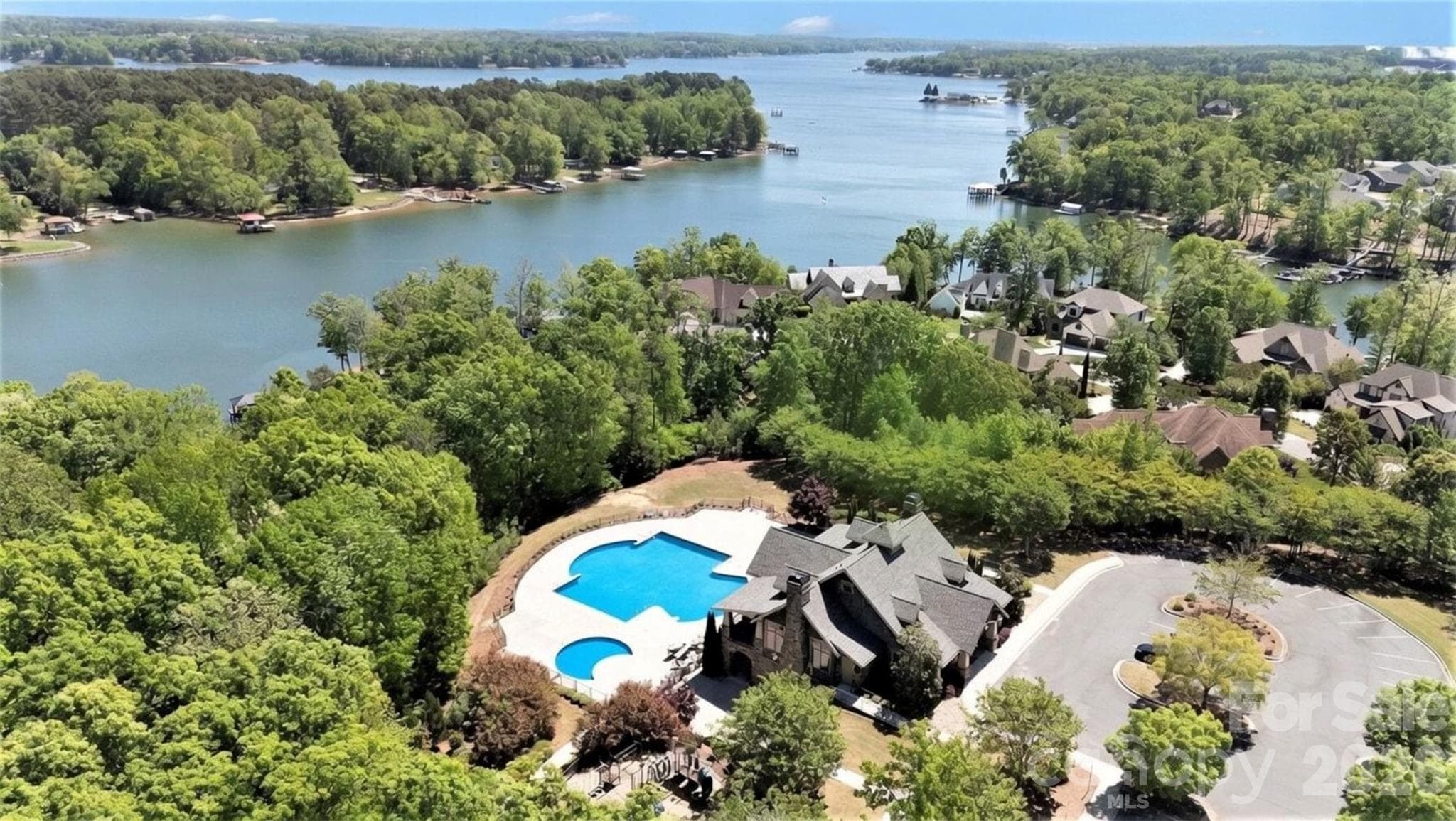 Community pool, splash pad, and clubhouse, with the lake as the backdrop. - 8027 Longwaters Court, York