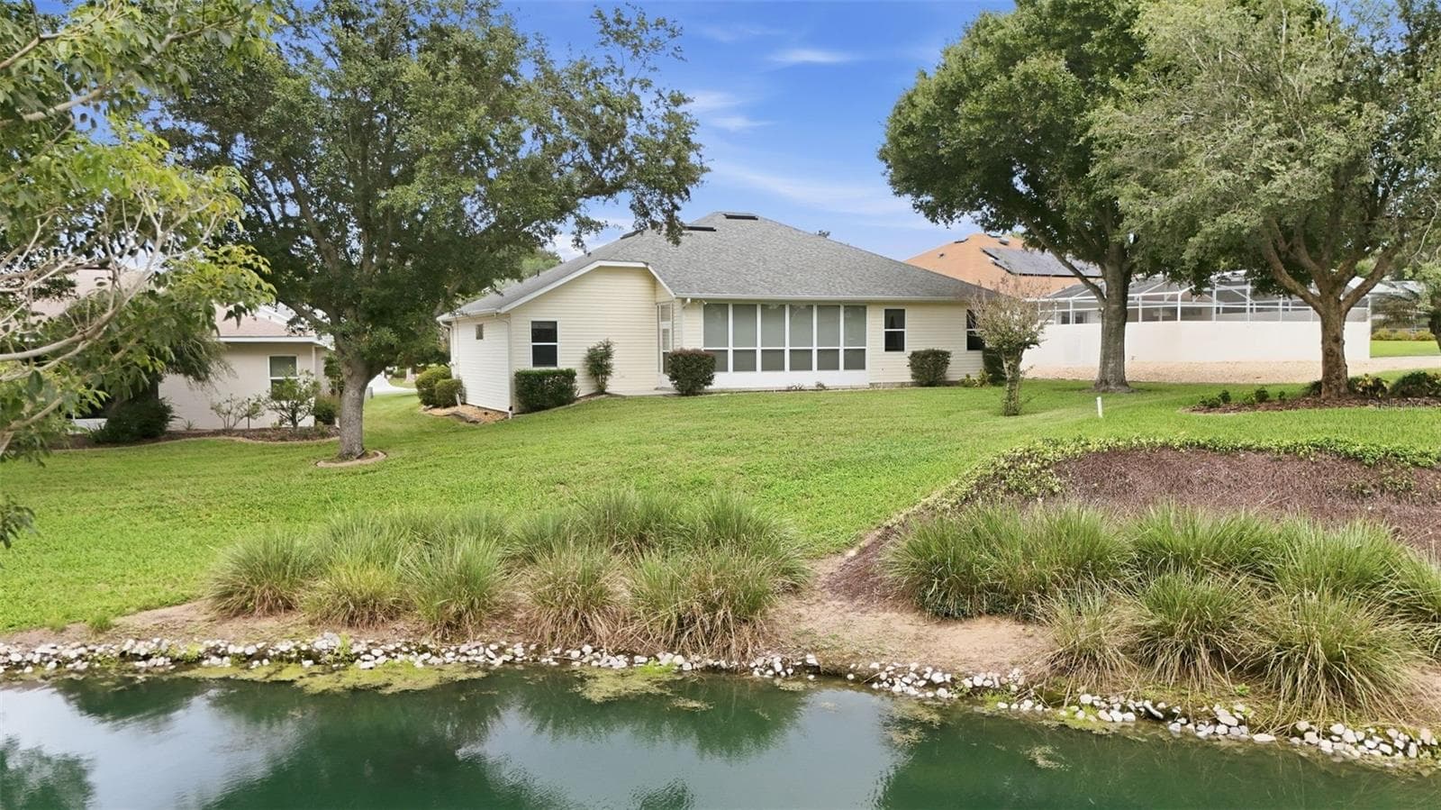 Peaceful water views complement the spacious backyard and enclosed lanai. - 5596 FREEPORT DR, TAVARES