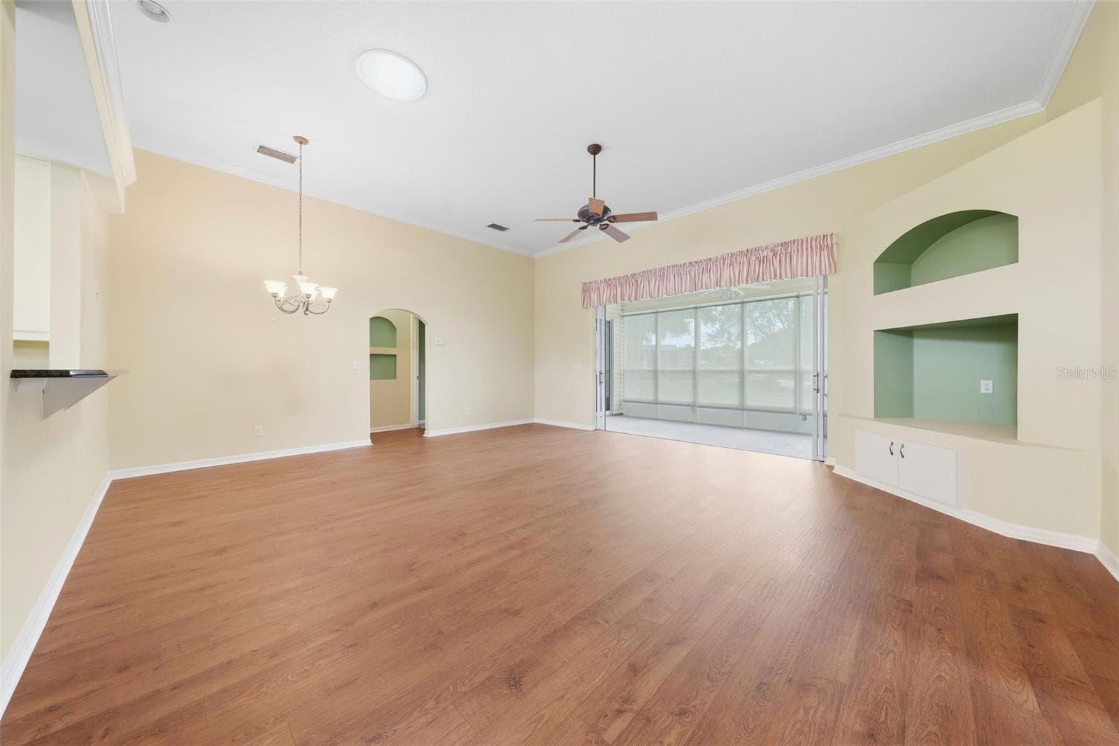 Spacious open living area with a desirable split-bedroom floor plan vaulted ceilings, and warm wood flooring. - 5596 FREEPORT DR, TAVARES
