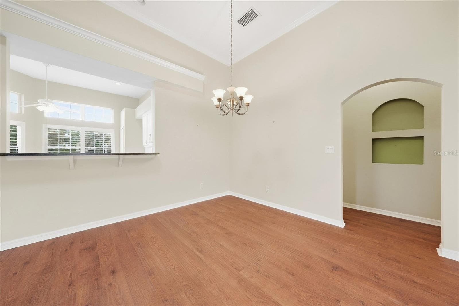 Spacious dining area with vaulted ceilings and warm wood flooring. - 5596 FREEPORT DR, TAVARES