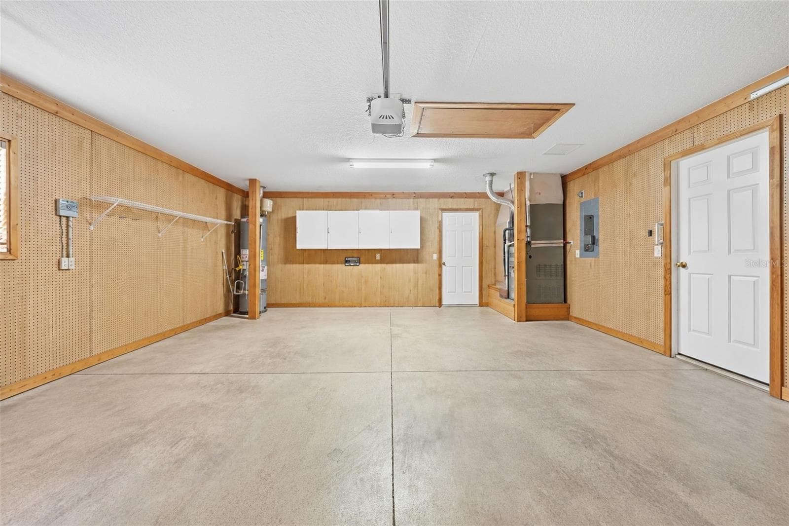 Spacious garage with built-in storage, workshop space, and convenient attic access! - 5596 FREEPORT DR, TAVARES
