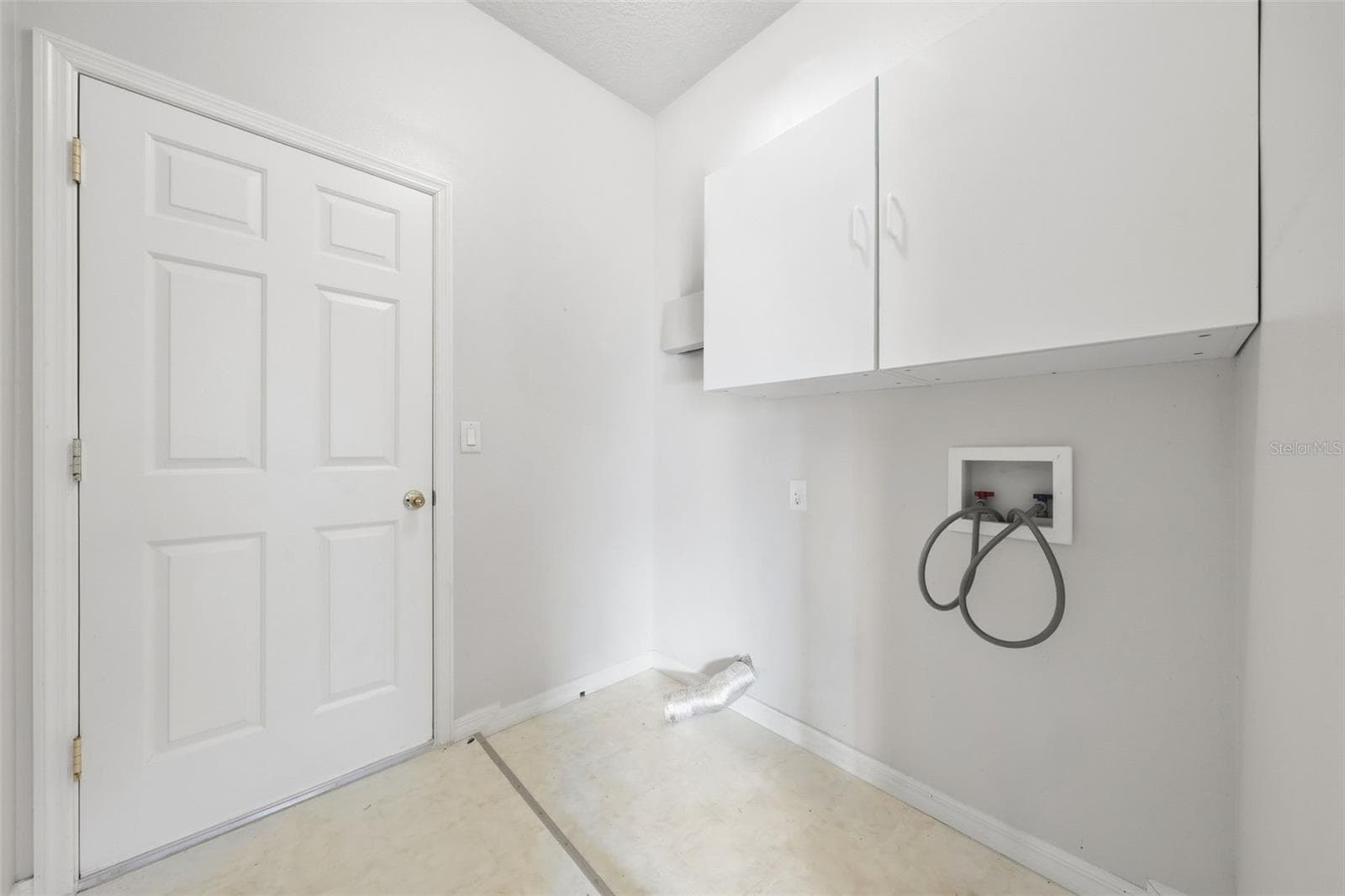 Convenient indoor laundry room with built-in storage cabinets. - 5596 FREEPORT DR, TAVARES