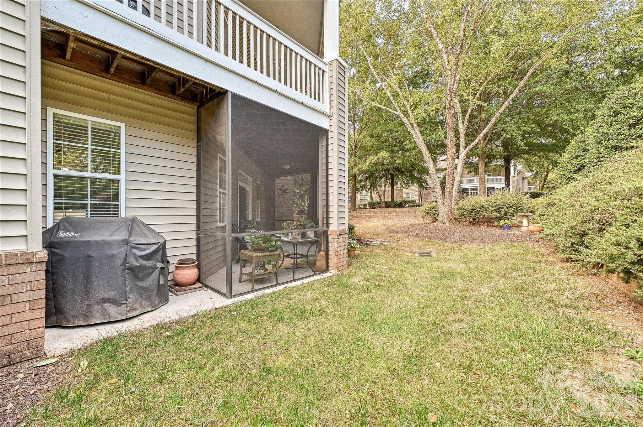 Ground-level screened porch opens to a landscaped outdoor area, adding convenient indoor-outdoor living. - 9009 Rosalyn Glen Road, Cornelius