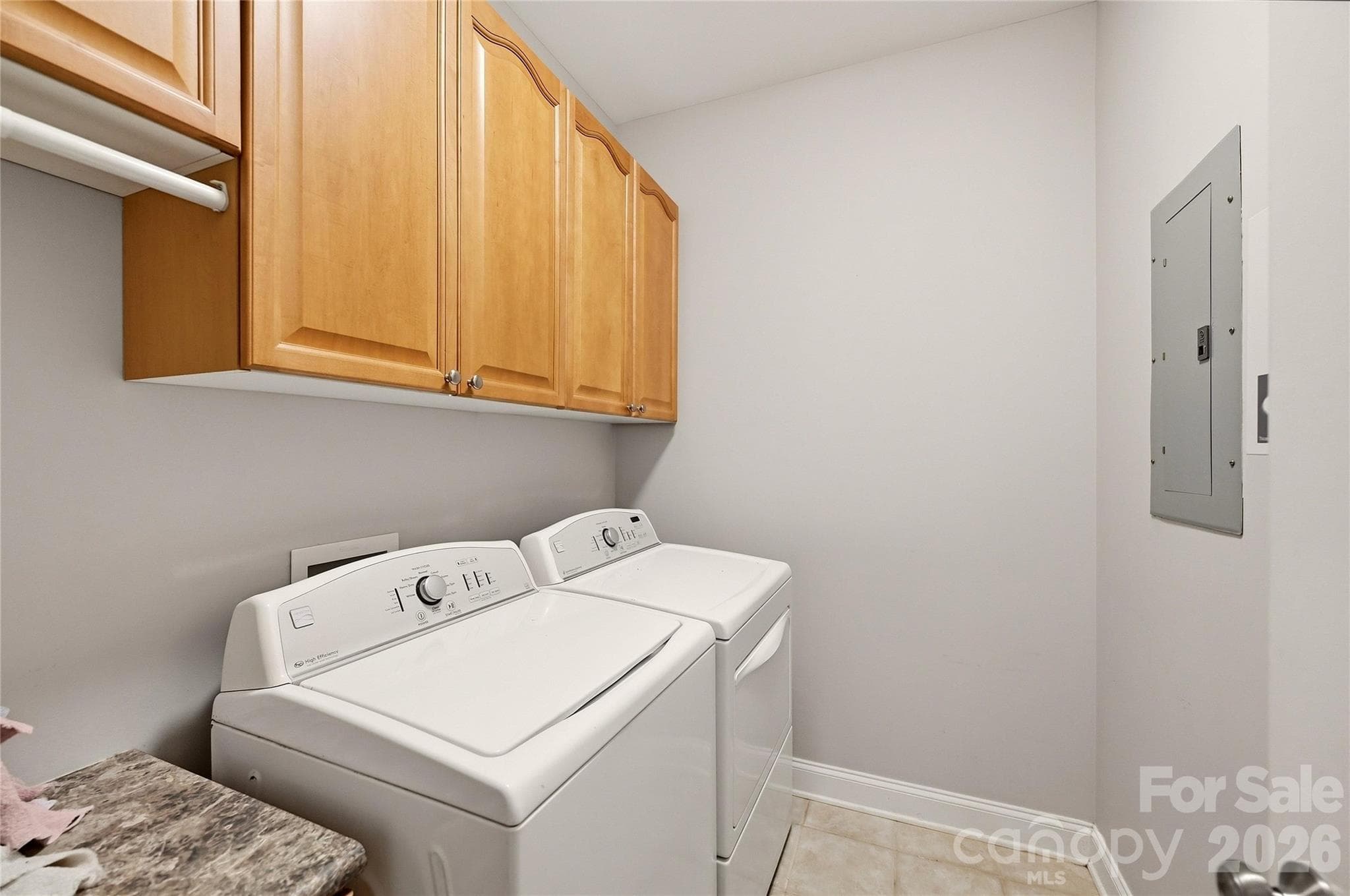 Main-level laundry room provides convenient storage cabinetry with the washer and dryer conveying. - 9009 Rosalyn Glen Road, Cornelius