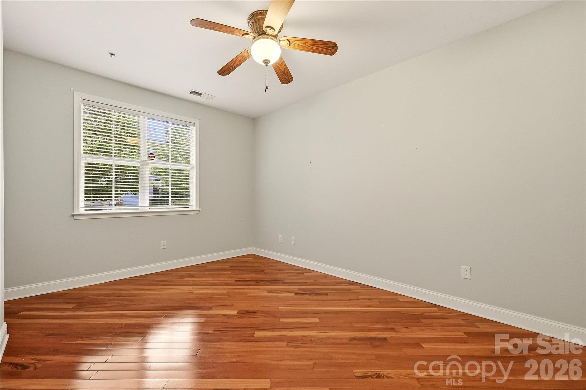 Additional secondary bedroom offers hardwood flooring, neutral finishes, and abundant natural light. - 9009 Rosalyn Glen Road, Cornelius