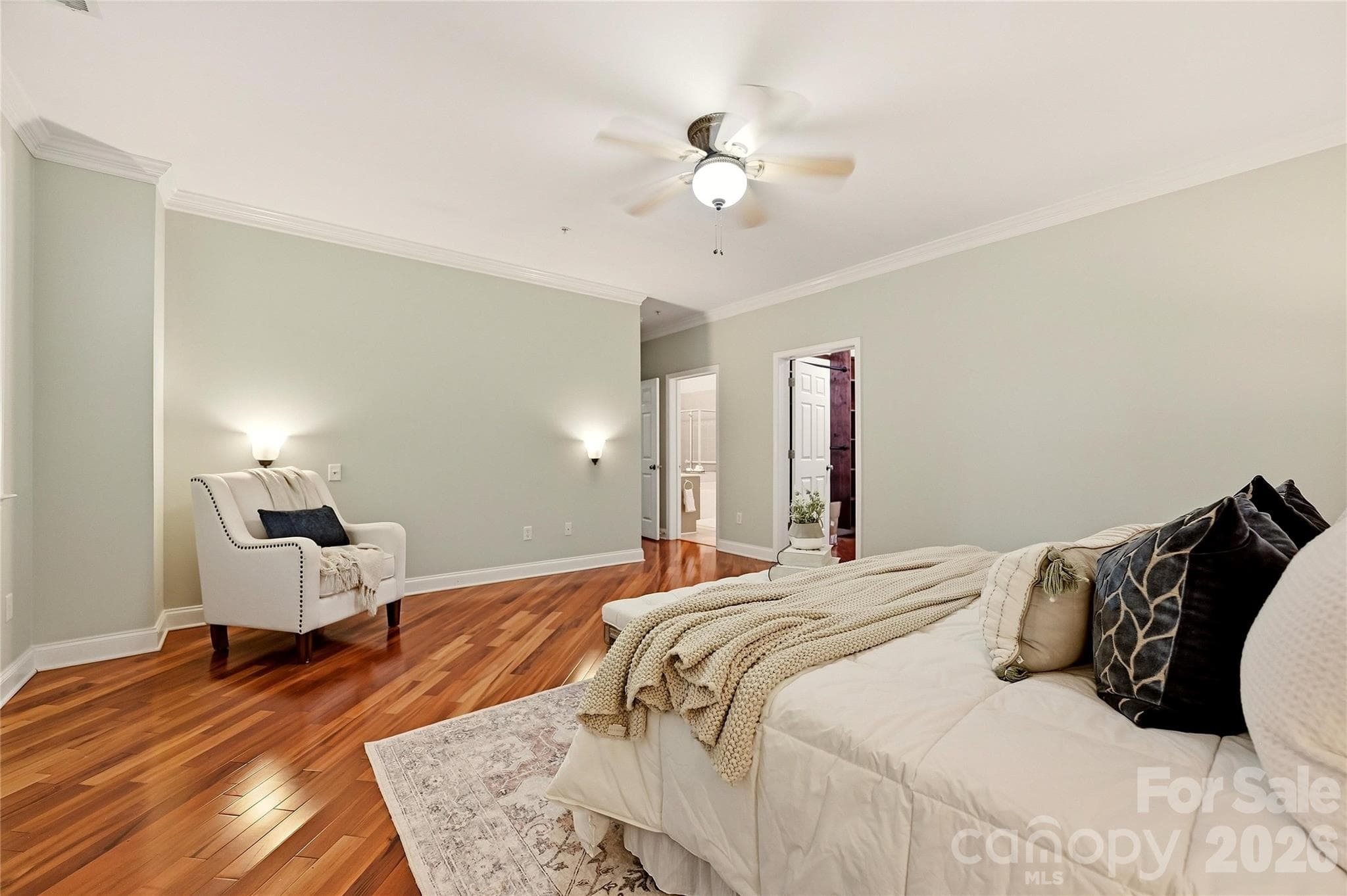 Primary suite provides generous living space, hardwood flooring, and convenient access to the private primary bath and walk-in closet. - 9009 Rosalyn Glen Road, Cornelius