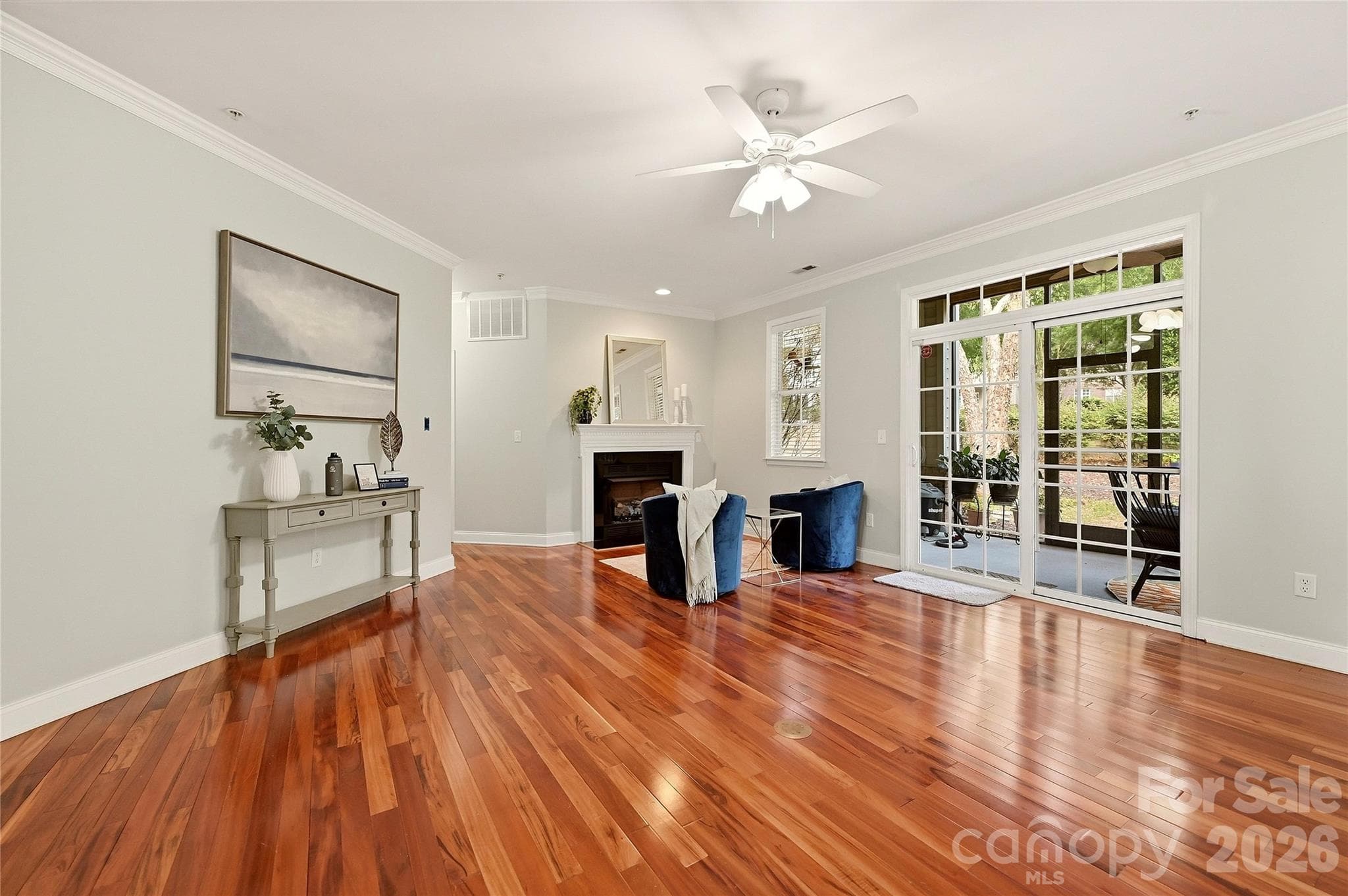 Sun-filled sitting area offers hardwood floors, a ceiling fan, and direct access to the covered screened porch. - 9009 Rosalyn Glen Road, Cornelius