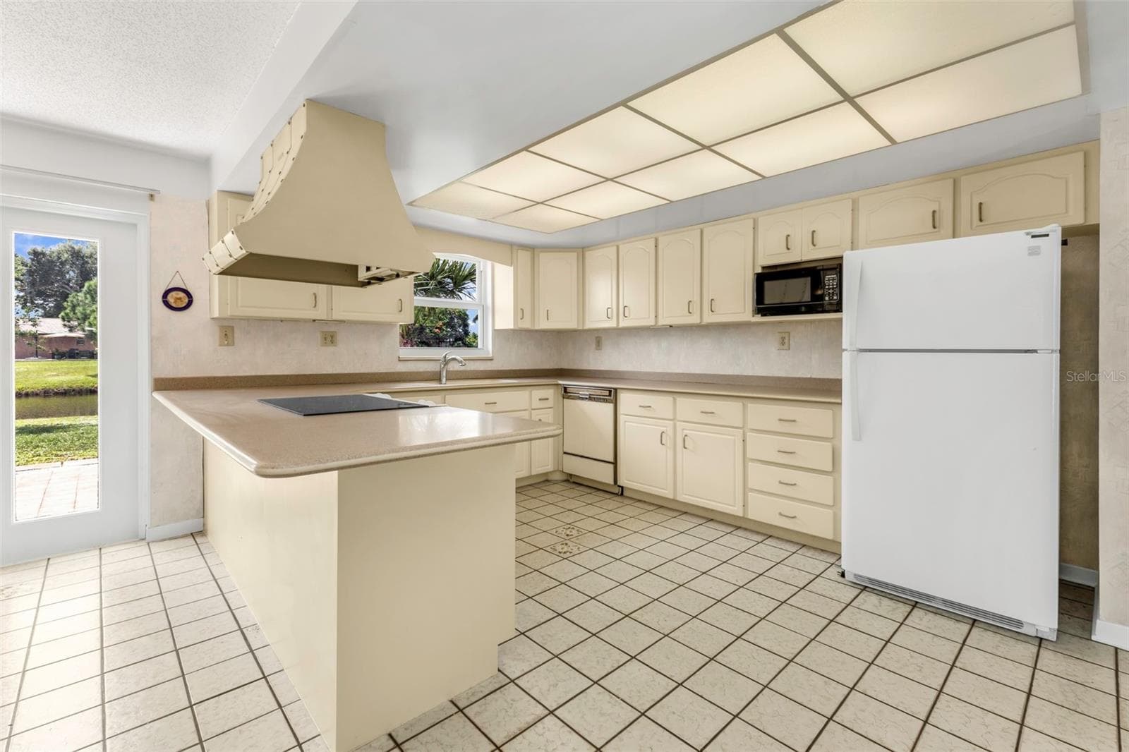 Kitchen with window views to your waterfront backyard and doorway to the back patio. - 160 ANNAPOLIS LN, ROTONDA WEST
