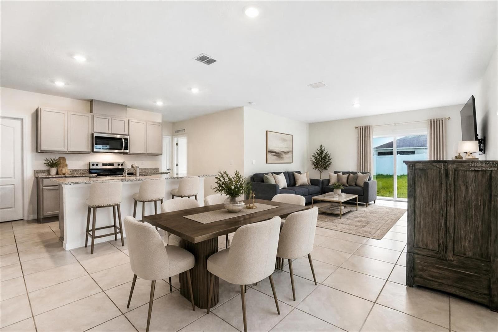 virtually staged dining kitchen living room combo - 2945 ELIO HAMMOCK DR, HARMONY