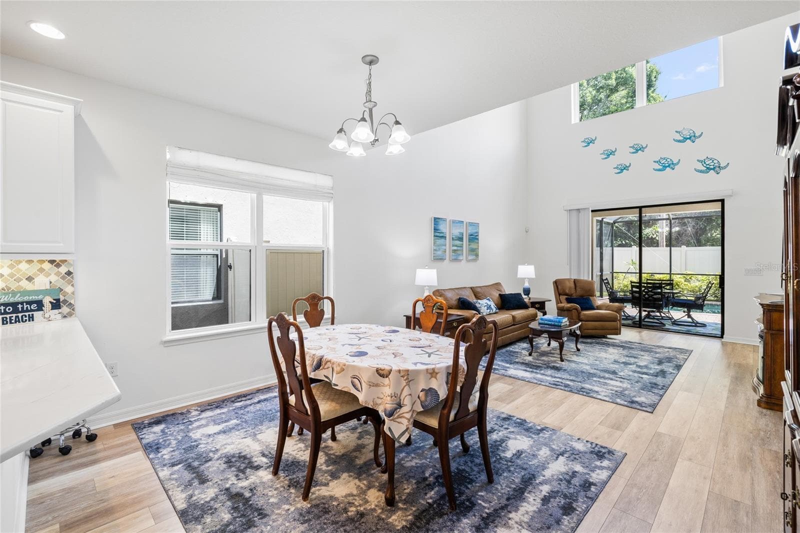 Dining area looking into Great Room with 20' ceilings, and over looking pool. - 8519 ARABELLA LN, SEMINOLE