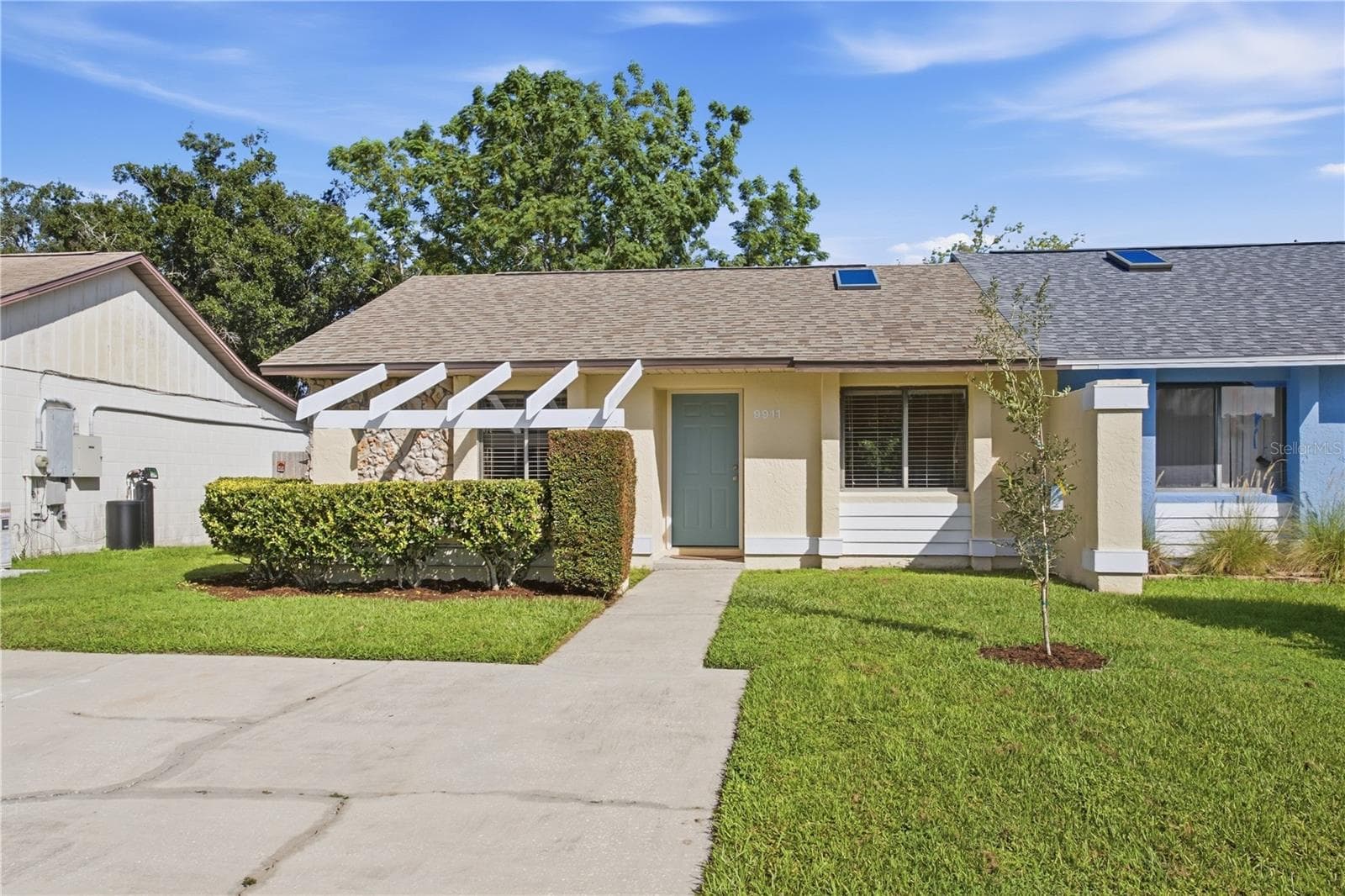 Landscaped front view, freshly painted, 2022 roof - 9911 LANCEWOOD ST, ORLANDO