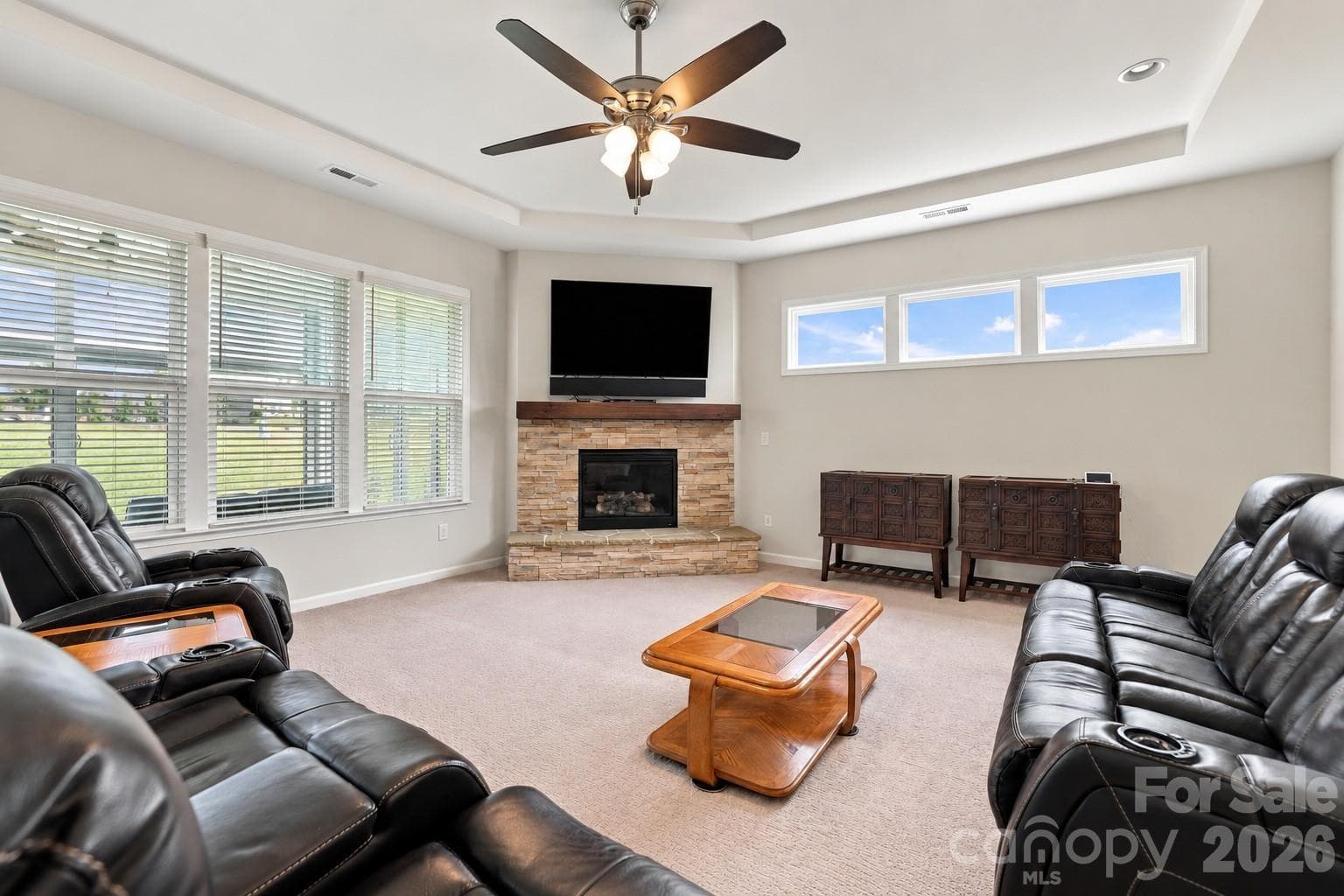 Great room designed to live large, with 10 foot trey ceiling, wall of windows and gas log, stone fireplace as its focal point. - 8504 Hope Run Court, Indian Land