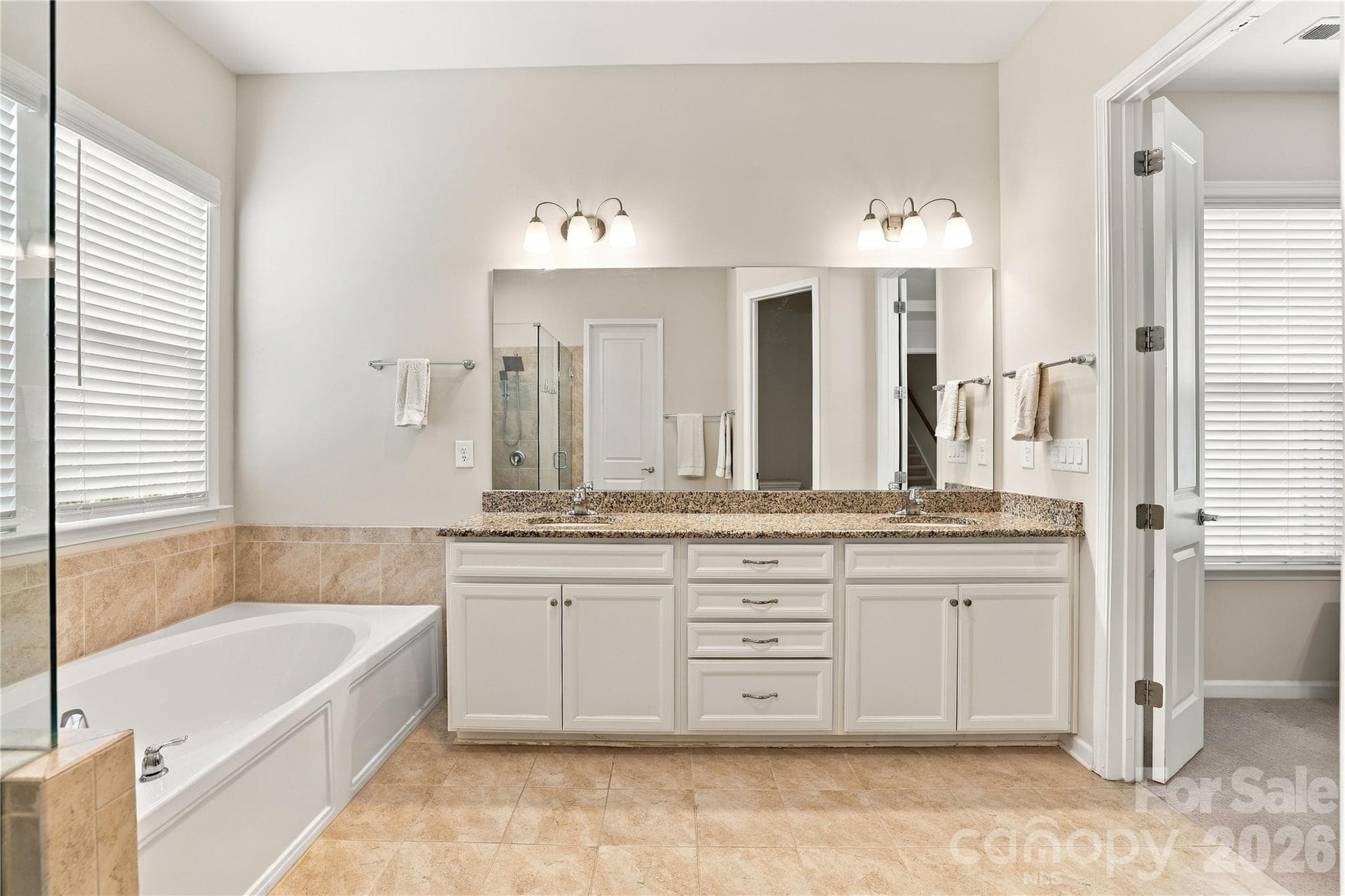 Primary bath: granite vanity counter, crisp white cabinetry, tile flooring and surround give the room a crisp, clean look. Picture window provides excellent natural light. - 8504 Hope Run Court, Indian Land