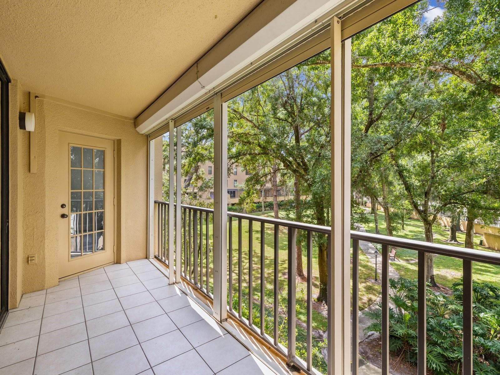 Tiled patio with entry to primary suite - 3076 EASTLAND BLVD #203, CLEARWATER