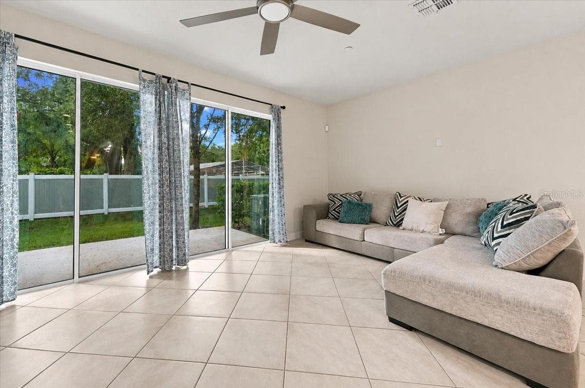 Spacious living room with sliding glass doors opening to the backyard - 7560 ALOMA PINES CT, WINTER PARK