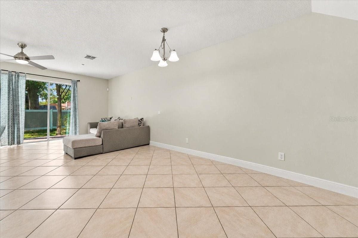 Open-concept living area with tile flooring and abundant natural light - 7560 ALOMA PINES CT, WINTER PARK