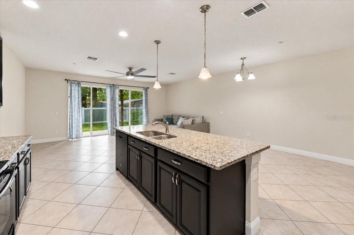 Kitchen island with pendant lighting flows seamlessly into the dining and living space - 7560 ALOMA PINES CT, WINTER PARK